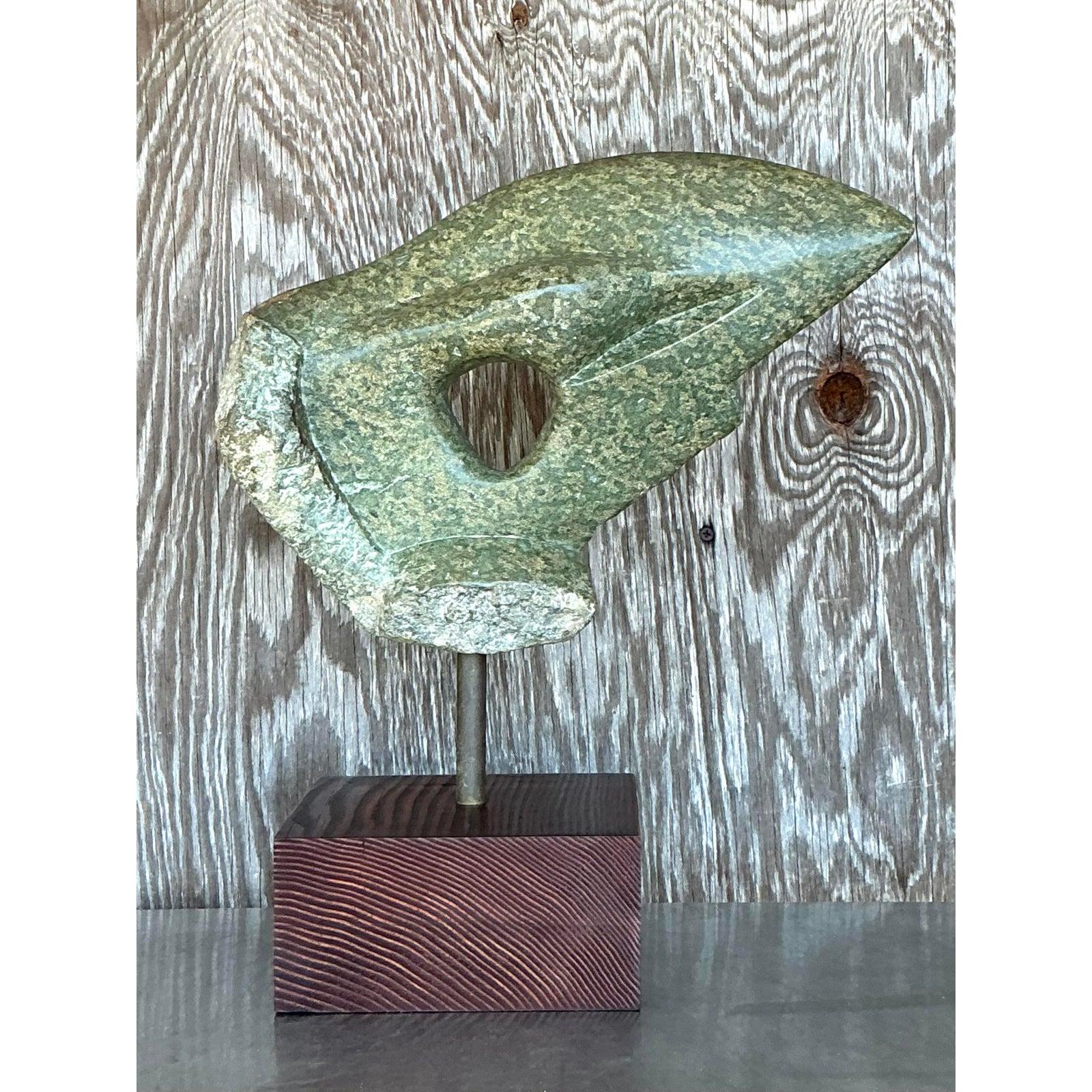 Introduci un tocco di eleganza artistica nel tuo spazio con questa scultura di pietra astratta Vintage Boho, un pezzo accattivante che incarna il fascino libero del design bohémien. Scolpita in pietra verde maculata, questa scultura presenta una