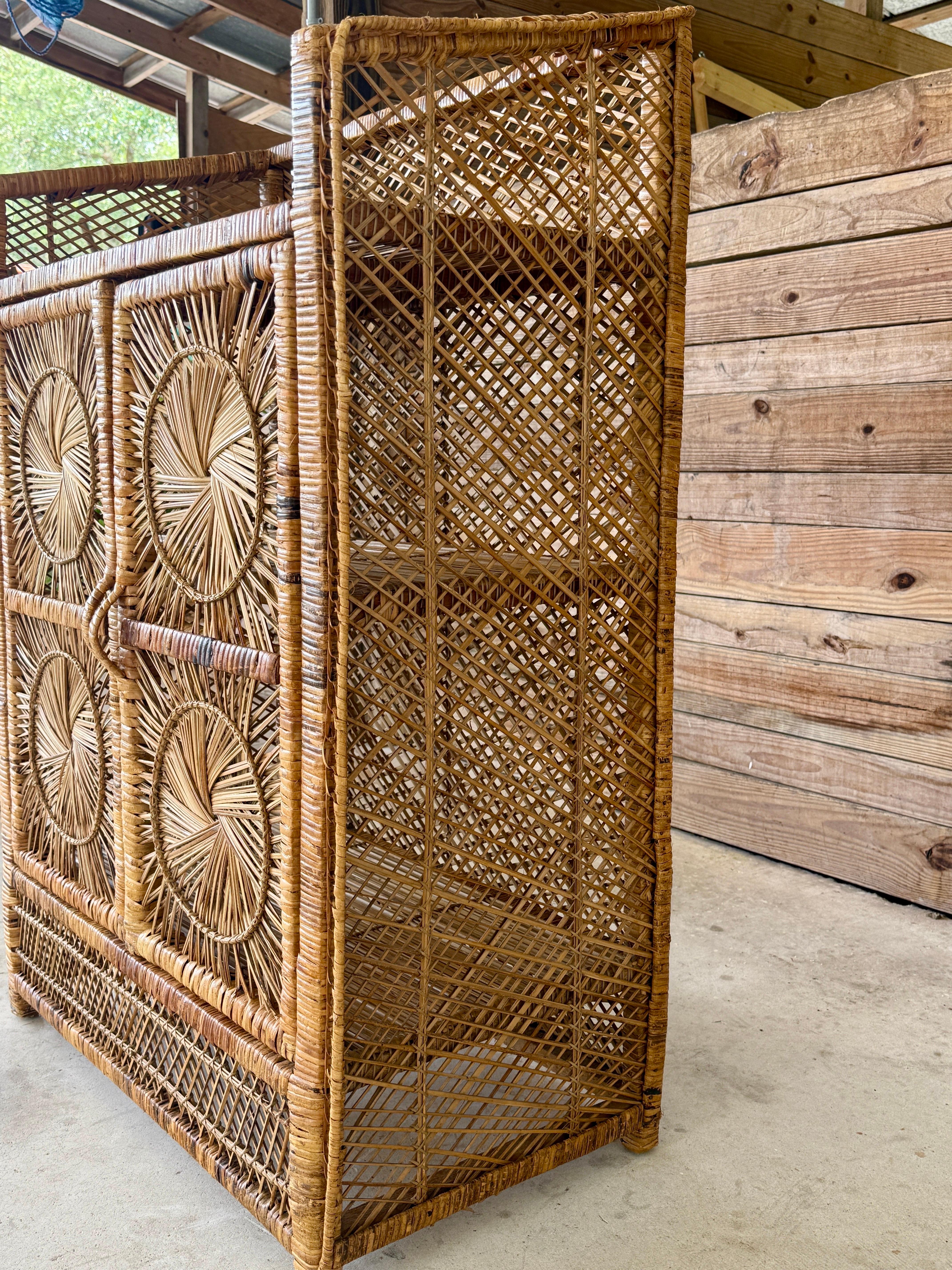 Véritable curiosité tropicale, ce meuble en rotin buri du milieu du 20e siècle présente un motif en forme de rayon de soleil tissé sur chacun des quatre panneaux de la façade. Construite en buri naturel et en rotin tressés à la main, cette pièce met
