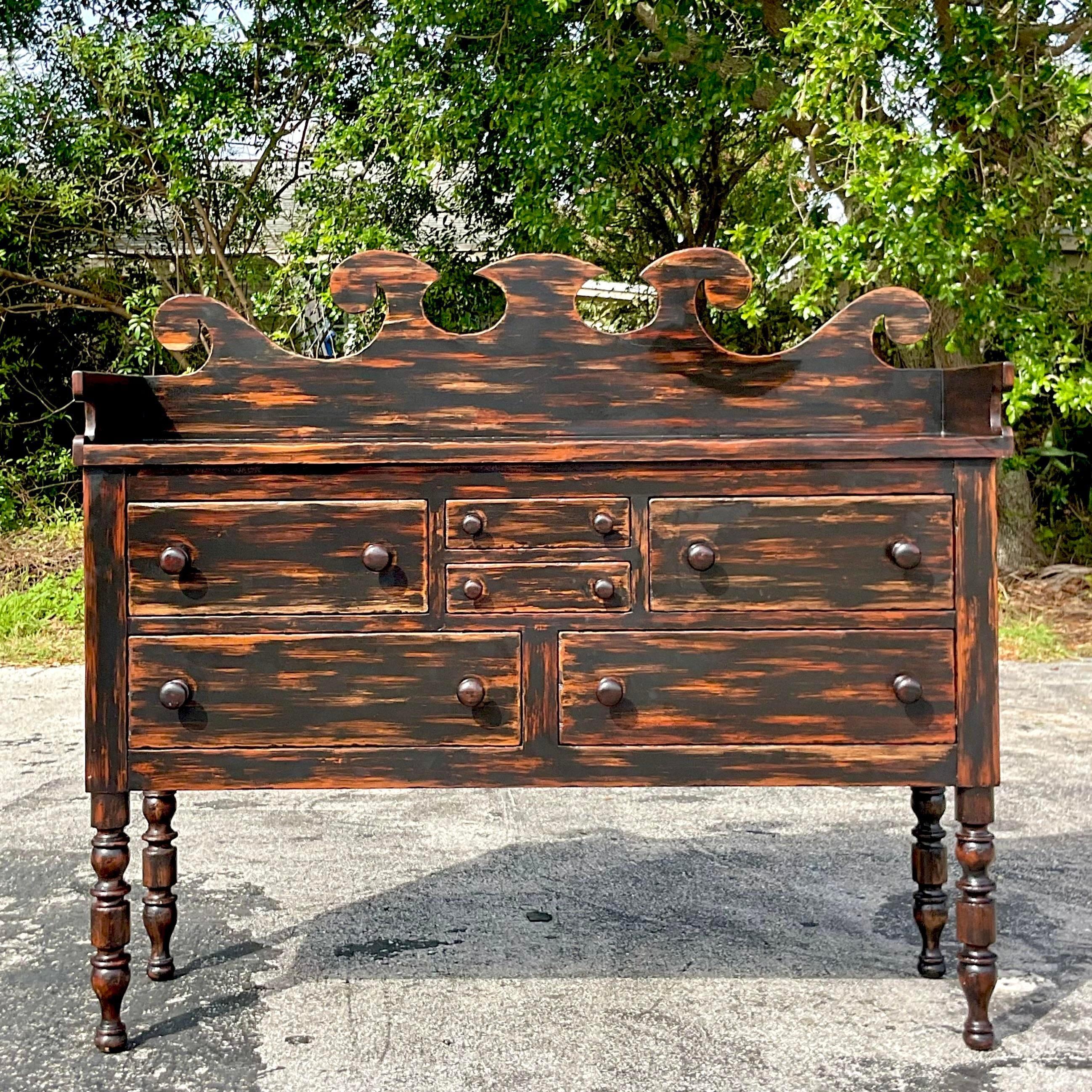 Embrace the allure of vintage charm and modern sophistication with this Currey and Company credenza. Crafted with a primitive black finish, it exudes rustic elegance while adding a touch of bohemian flair to any space. Perfect for storing essentials