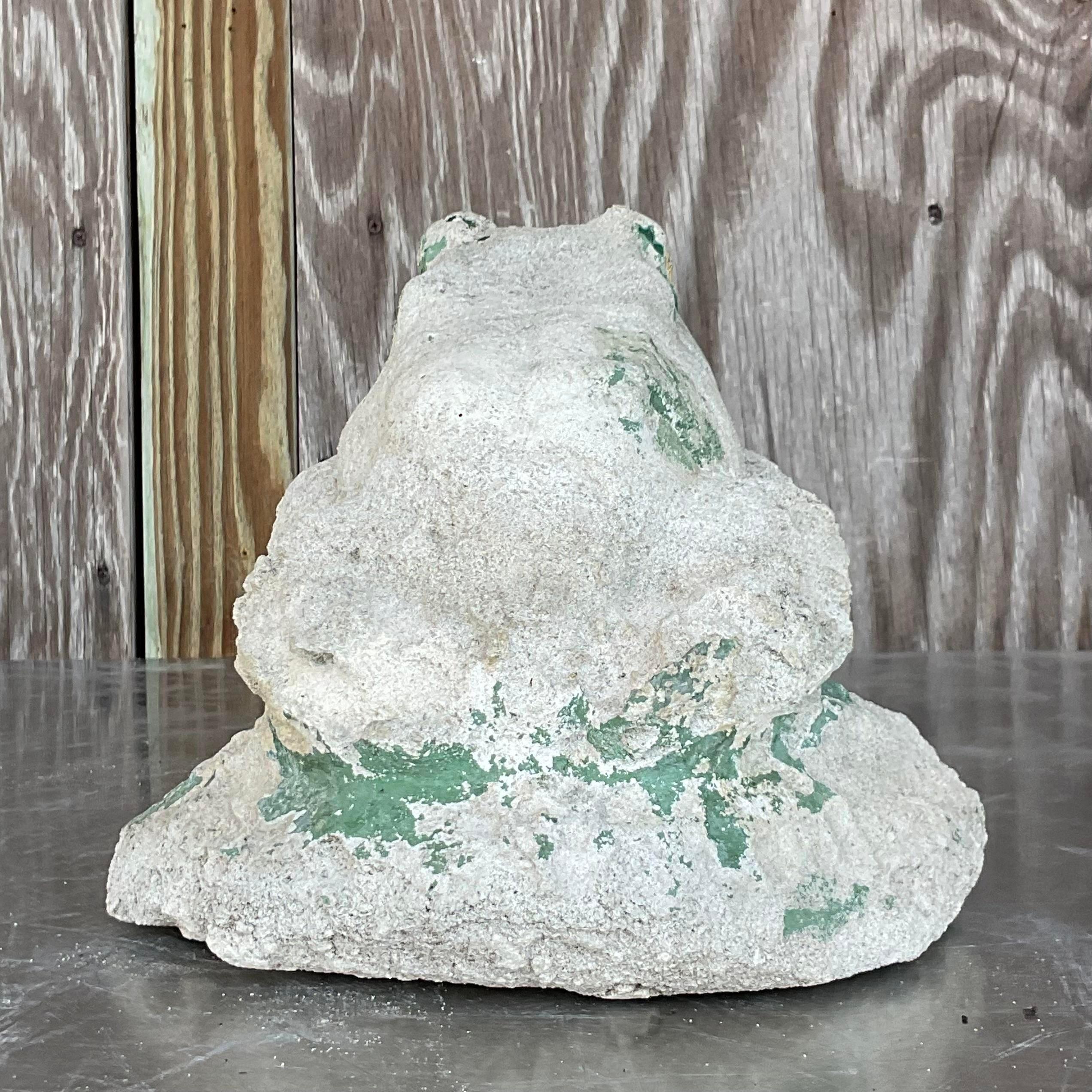 Add a touch of whimsy to your decor with this vintage boho patinated cast concrete frog. Crafted with rustic charm and enduring appeal, this piece brings a sense of playful sophistication to any space. Perfect for garden accents or indoor decor, it