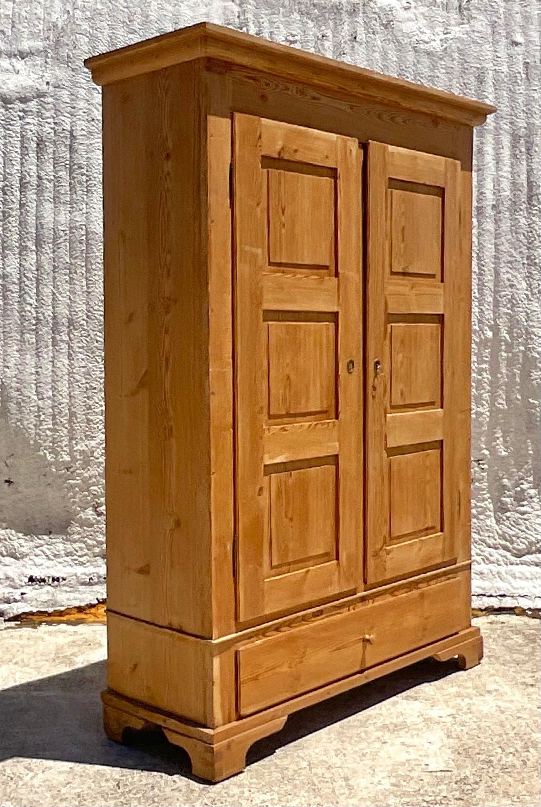 A striking vintage Boho armoire. A chic pine panel armoire with interior shelving. Perfect as a linen closet or for your towels in your pool house. You decide! Acquired from a Palm Beach estate.