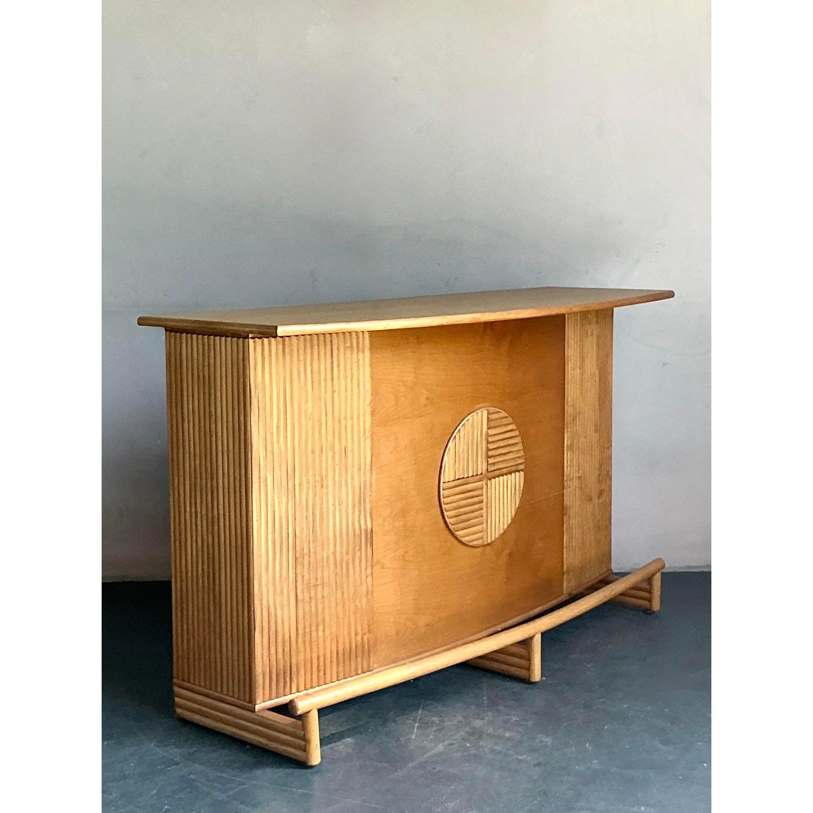 Elevate your entertaining space with this exceptional vintage dry bar from the 1970s. This piece beautifully marries Mid-Century Modern structure with Boho-inspired materials, featuring a striking combination of a smooth wood veneer front and