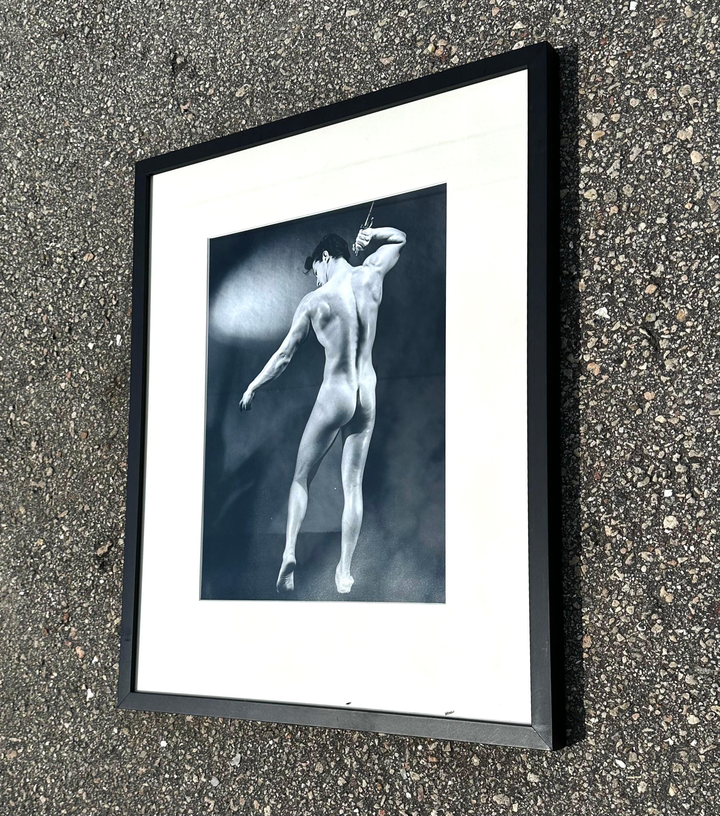 Questa foto che cattura l'attenzione ritrae un uomo forte e nudo con le spalle rivolte alla macchina fotografica. I colori tenui e monotoni rendono questo fotomontaggio audace ma di buon gusto. Acquistato da una proprietà di Palm Beach. 
