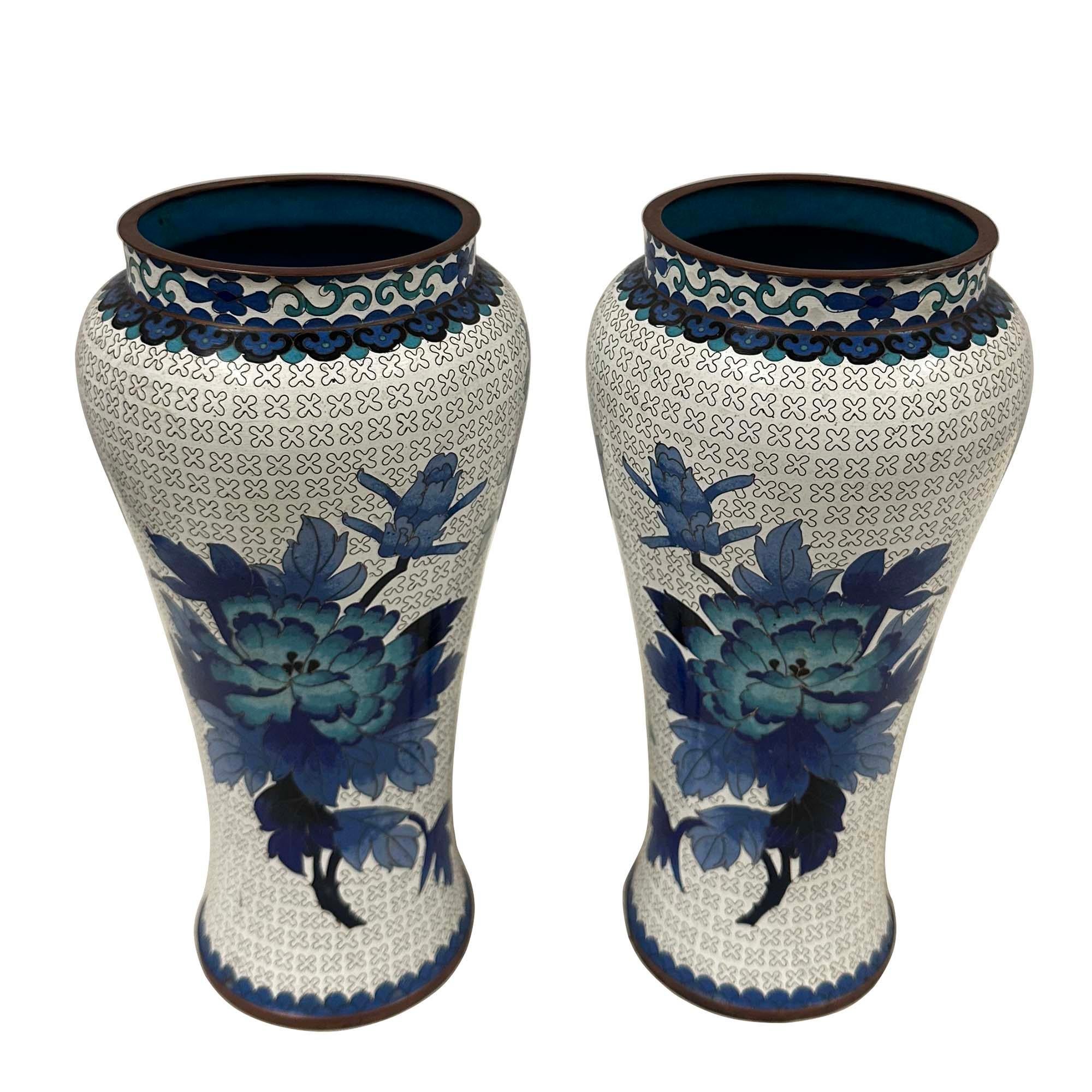 Questa coppia di vasi cloisonné con un disegno floreale blu e bianco, Penney, significa Ricchezza e splendore. Il cloisonné è una tecnica di decorazione di oggetti in metallo con materiali colorati tenuti in posizione o separati da strisce o fili