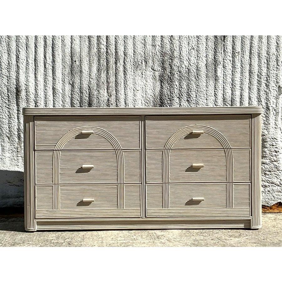 Bring coastal elegance to your home with this vintage arched pencil reed dresser. Featuring a timeless design, this piece is crafted with meticulous attention to detail, showcasing a smooth, natural texture and graceful curves. Its spacious drawers