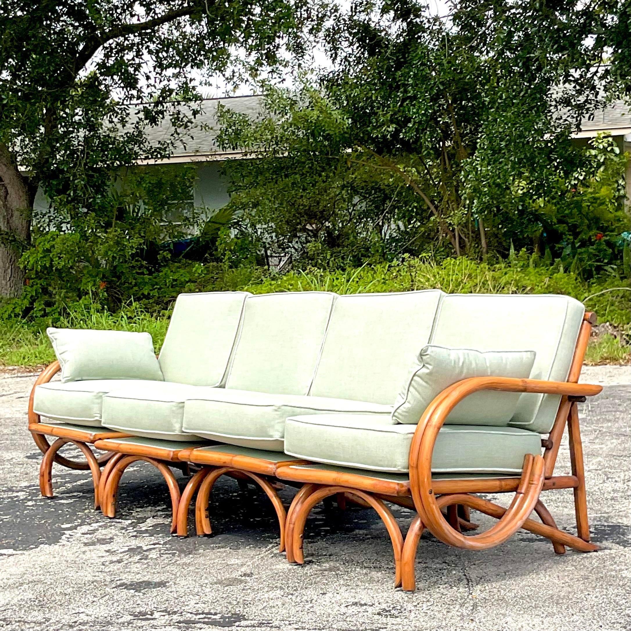 Eine fantastische Vintage Coastal vier Sitz Sofa. Schickes gebogenes Rattan mit Schlaufenseiten und hoher Rückenlehne. Vollständig restauriert mit einer kompletten Überarbeitung des Rattans und einer neuen Sunbrella-Polsterung mit Krypton-Behandlung