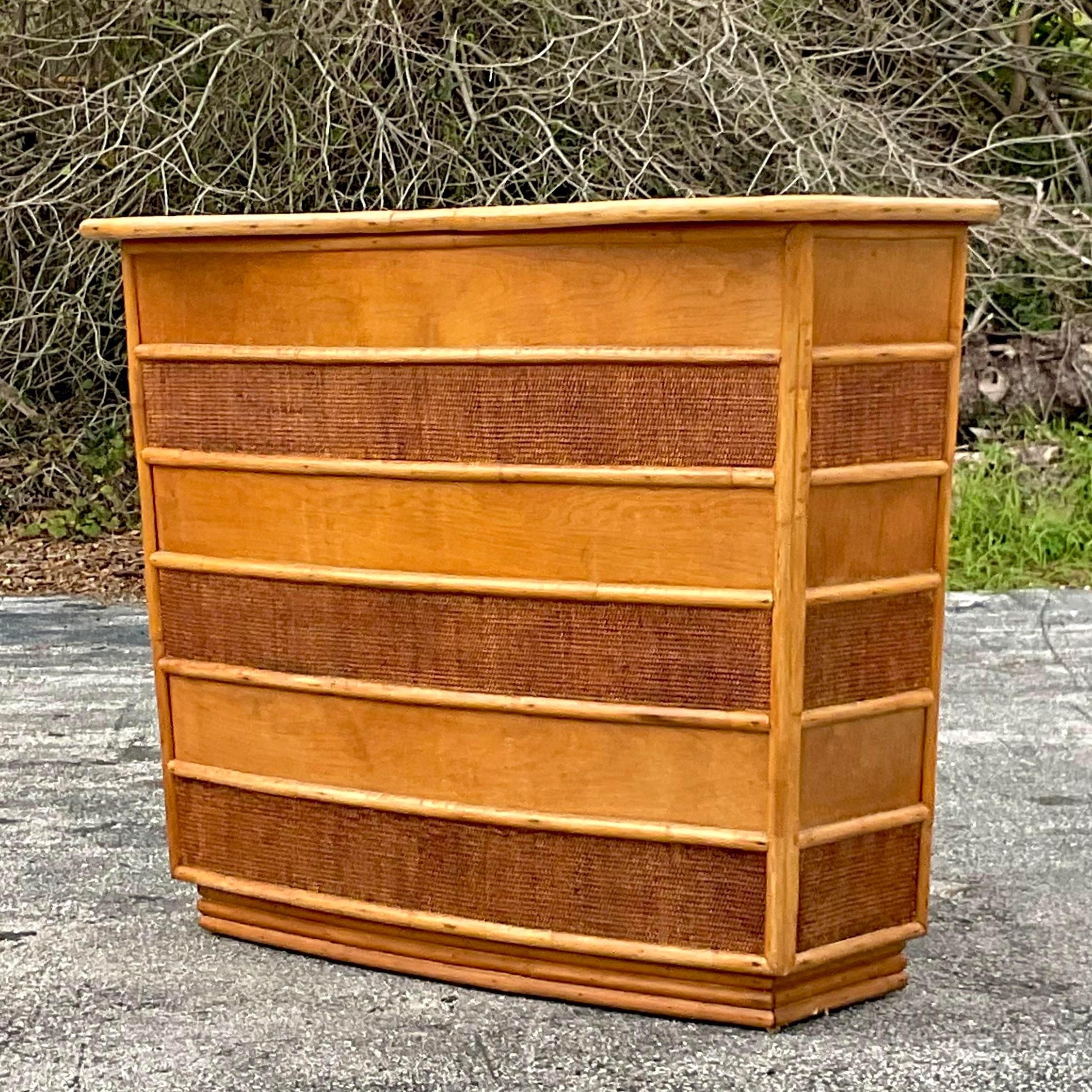 A fantastic vintage coastal dry bar. A gorgeous retro shape with bands of natural seagrass around the frame. Period kidney shaped laminate top. Lots of great storage behind. Acquired from a Palm Beach estate.