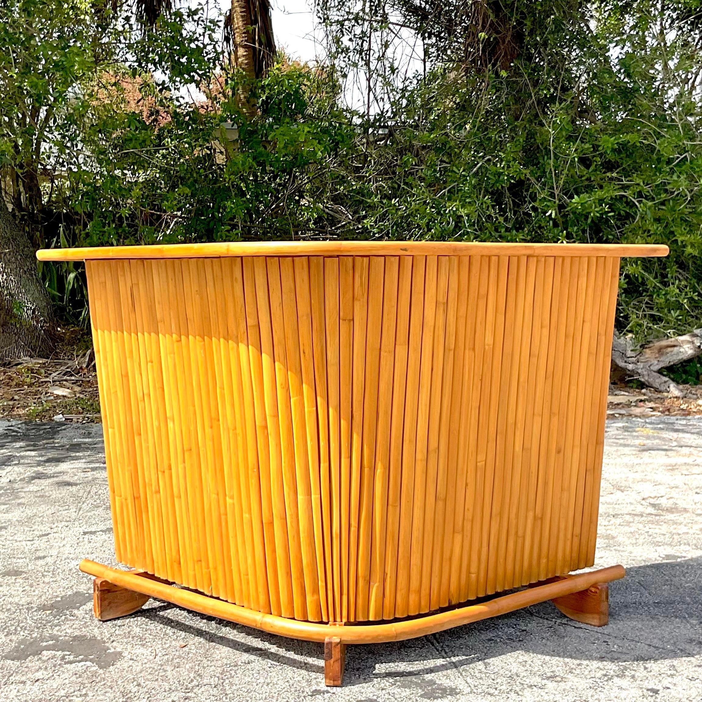 A fantastic vintage Coastal dry bar. A chic thick rattan in a cool retro boomerang shape. Laminate wood top for easy care. Lots of great storage below. Acquired from a Palm Beach estate.