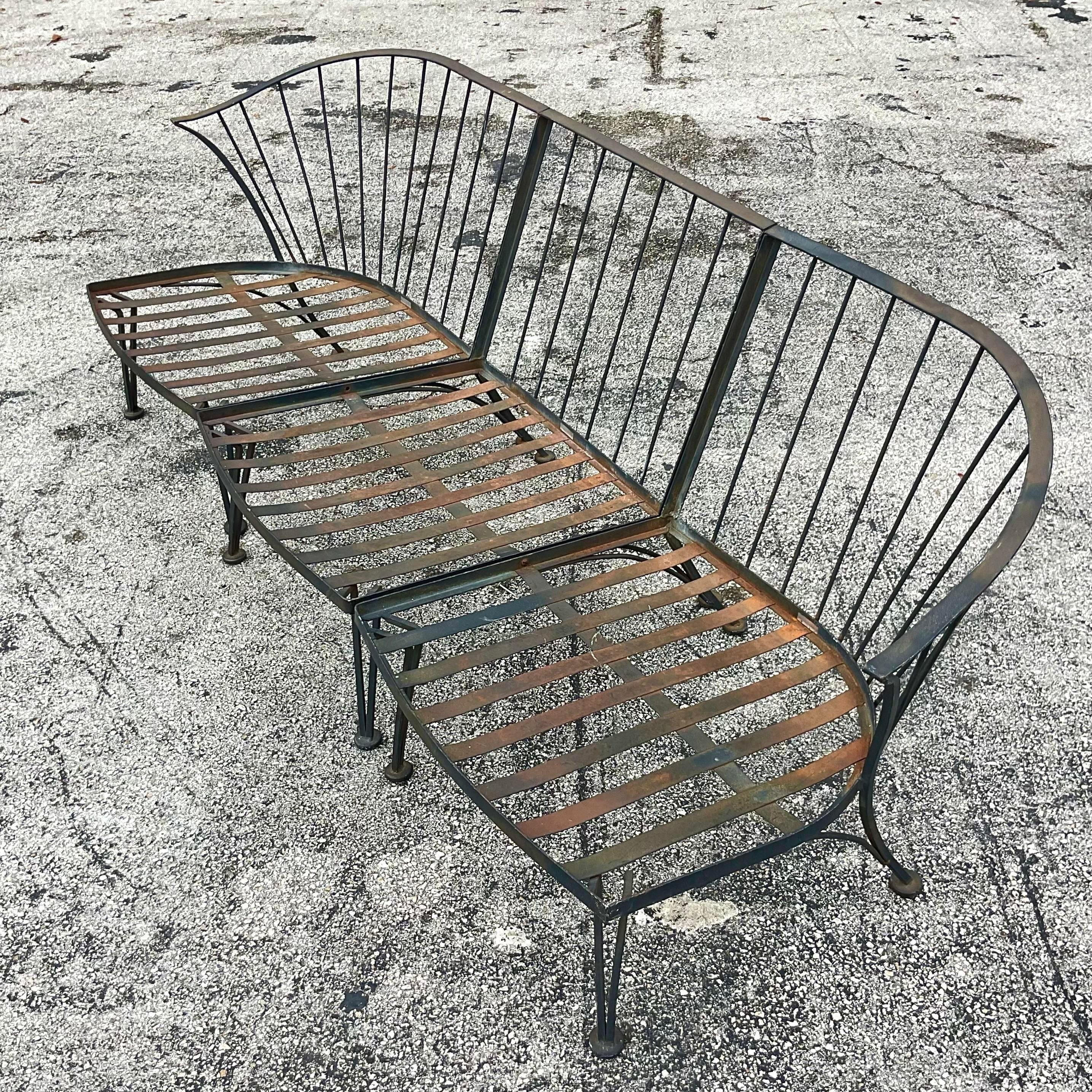 A fabulous vintage Coastal outdoor sofa. Made by the iconic Russell Woodard and tagged on the seat. Chic black wrought iron in a great curved shape. Acquired from a Palm Beach estate.