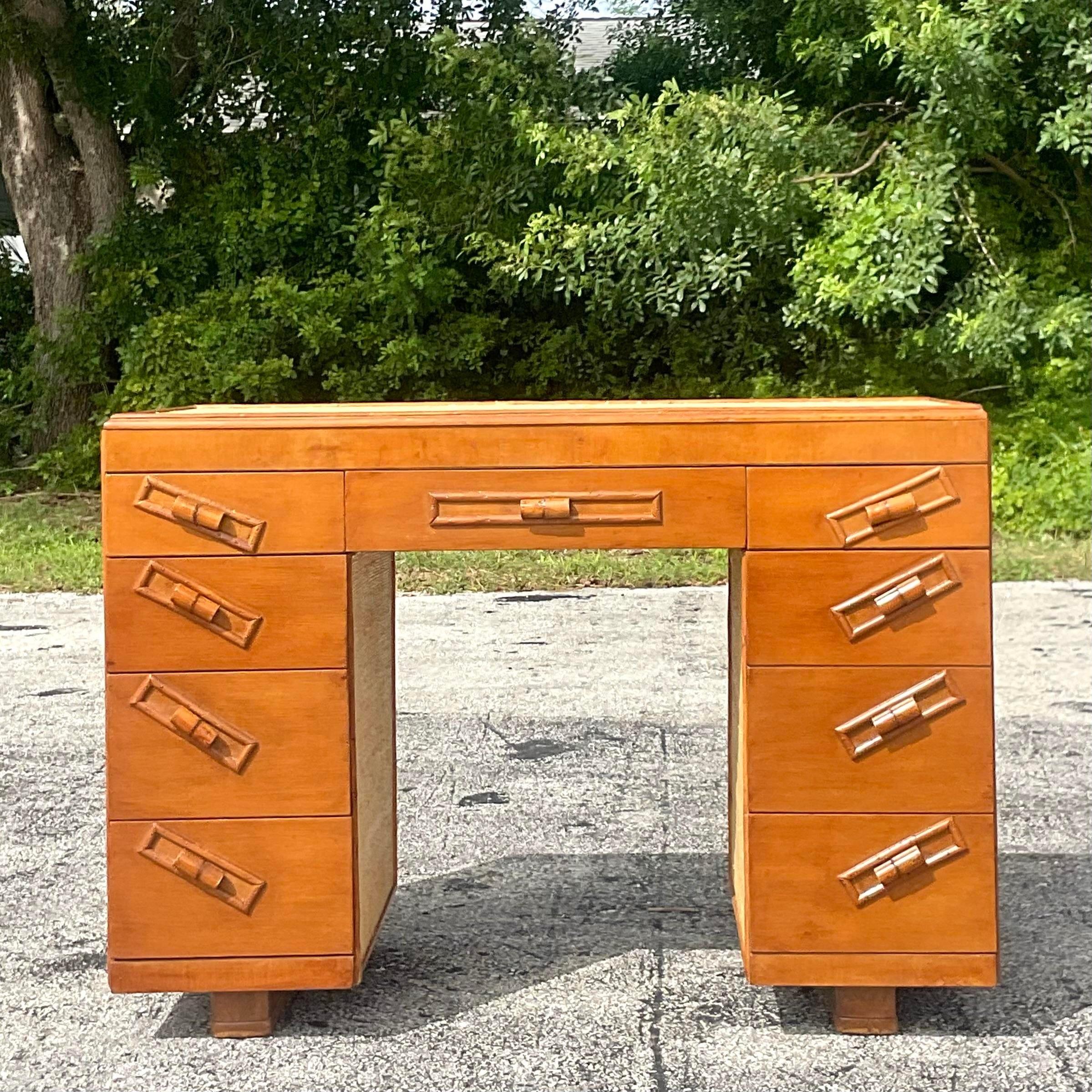 A fantastic vintage Coastal writing desk. A classic wood frame two tower desk with inset panels of Grasscloth. Charming period rattan drawer pulls. Acquired from a Palm Beach estate.