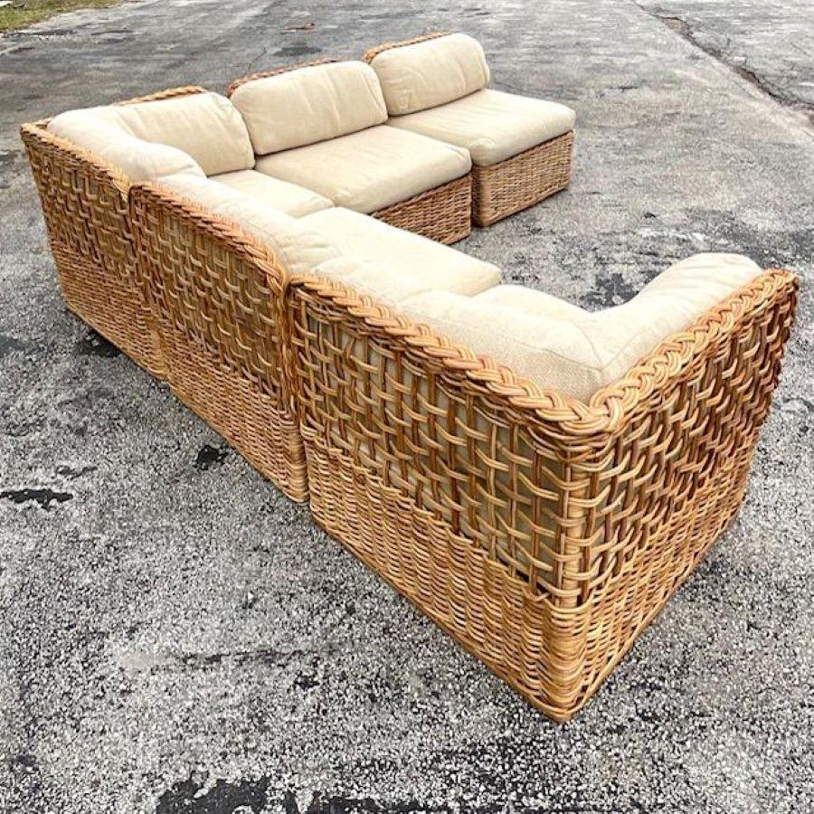 A fabulous vintage Coastal sectional sofa. A chic braided rattan frame with heavy upholstered cushions. Five separate pieces that can be rearranged to suit your space. Acquired from a Palm Beach estate.
