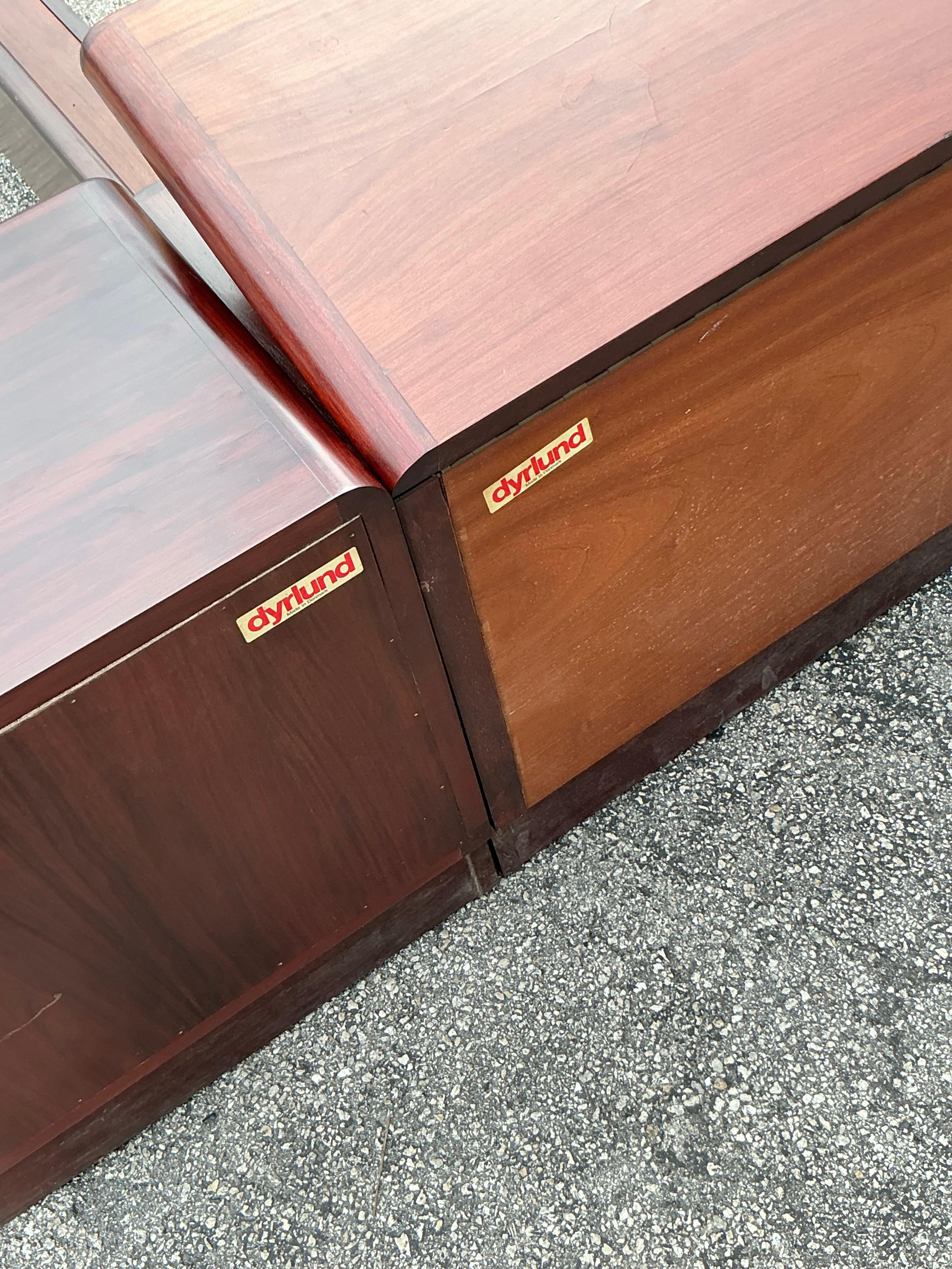 Pair of vintage Mid-Century Modern Drylund rosewood nightstands with rich grain and sleek profiles. Each features a streamlined design with a spacious drawer, standing on unique chair-ish bases that add character and stability. Perfect for adding