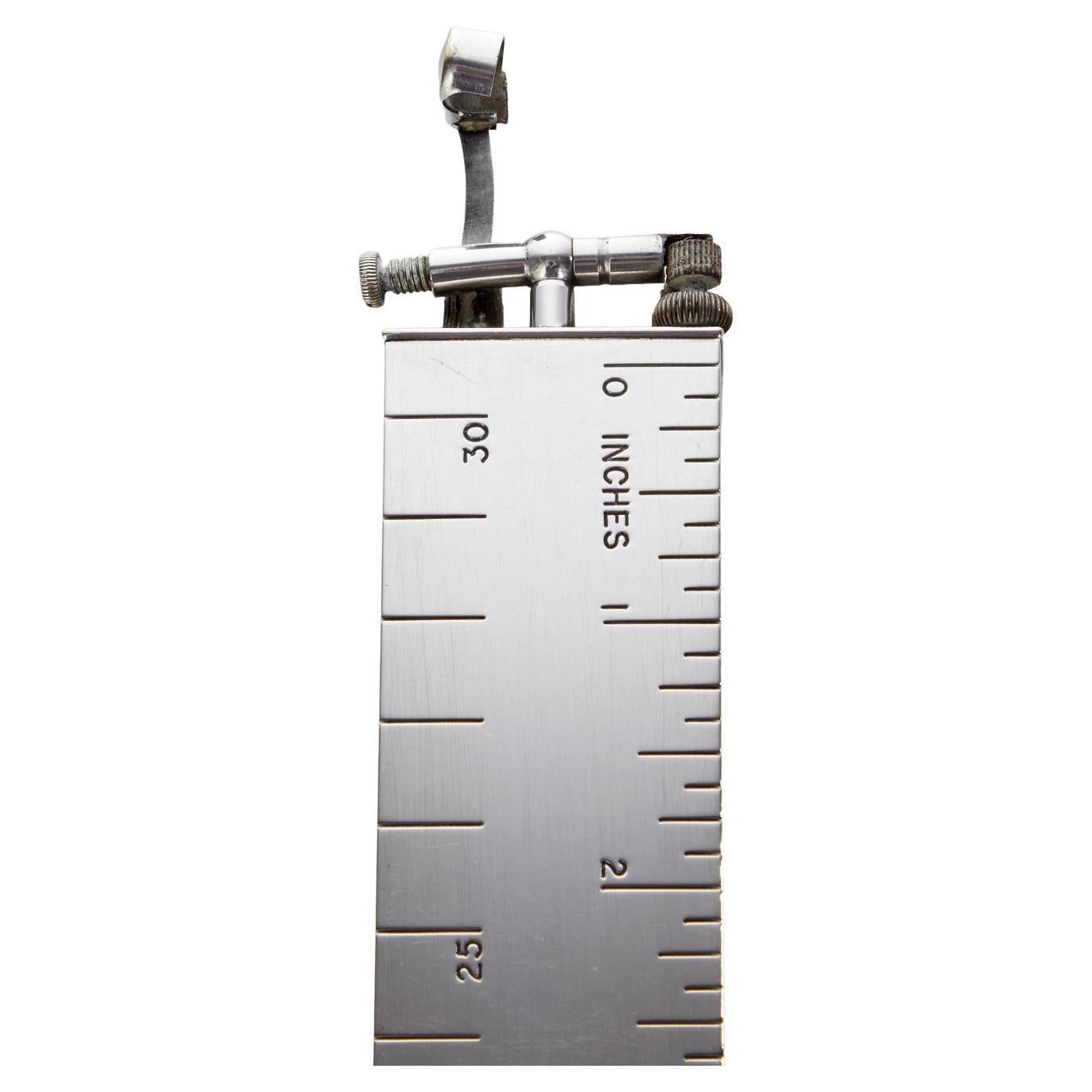 A wonderful mid 20th century vintage dunhill lighter & ruler date Circa 1950.

One of those iconic items by Dunhill, which is Marked on the base and lighter arm. 
Engraved Measurements both in inches and centimetres. The exterior is in good order