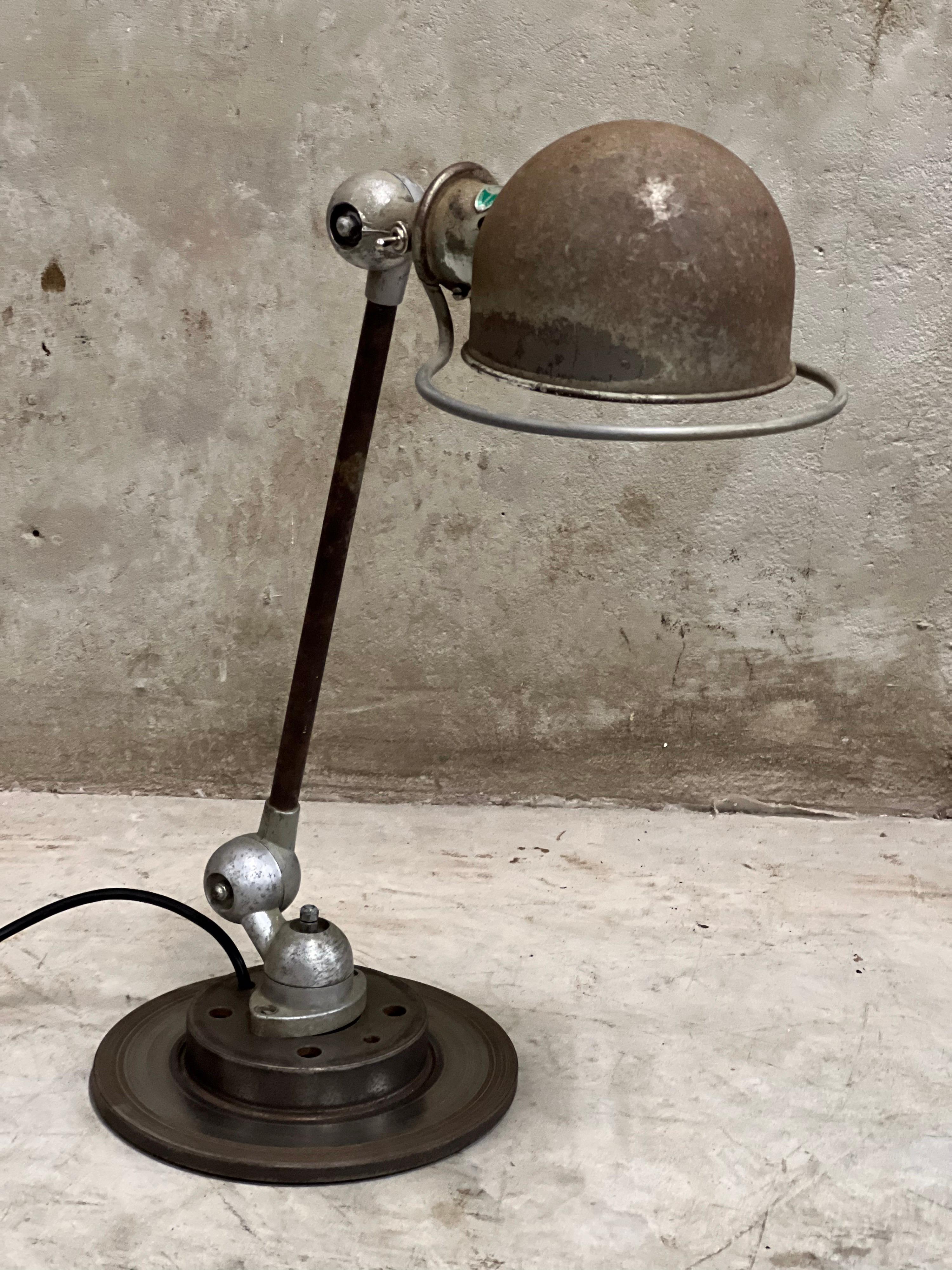 Industrial lamp by Jean-Louis Domecq for Jieldé, France. Original old Jieldé table lamp with a fantastic patina! E27 fitting including lamp. Placed on an old brake disc. Design icon from the 50s to the present. The ravages of time are certainly