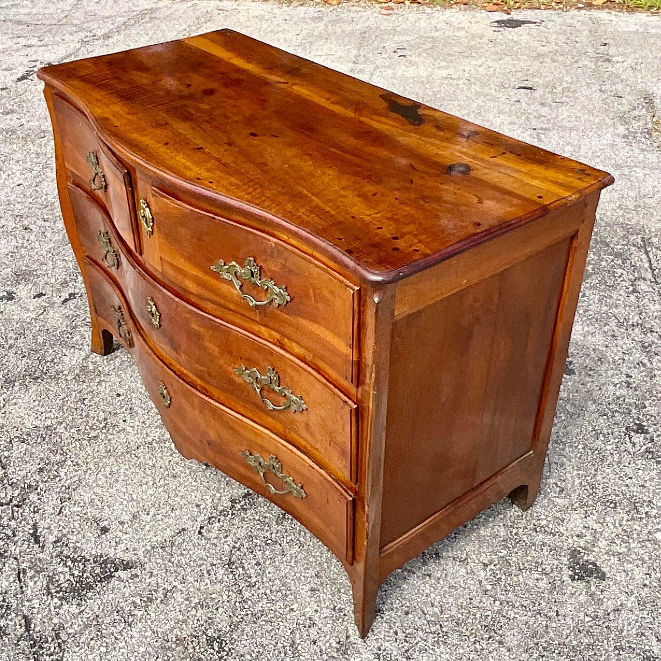 A fabulous vintage Italian chest of drawers. Incredible wood grain detail with a lovely roll front design. Heavy brass hardware. Acquired from a Palm Beach estate