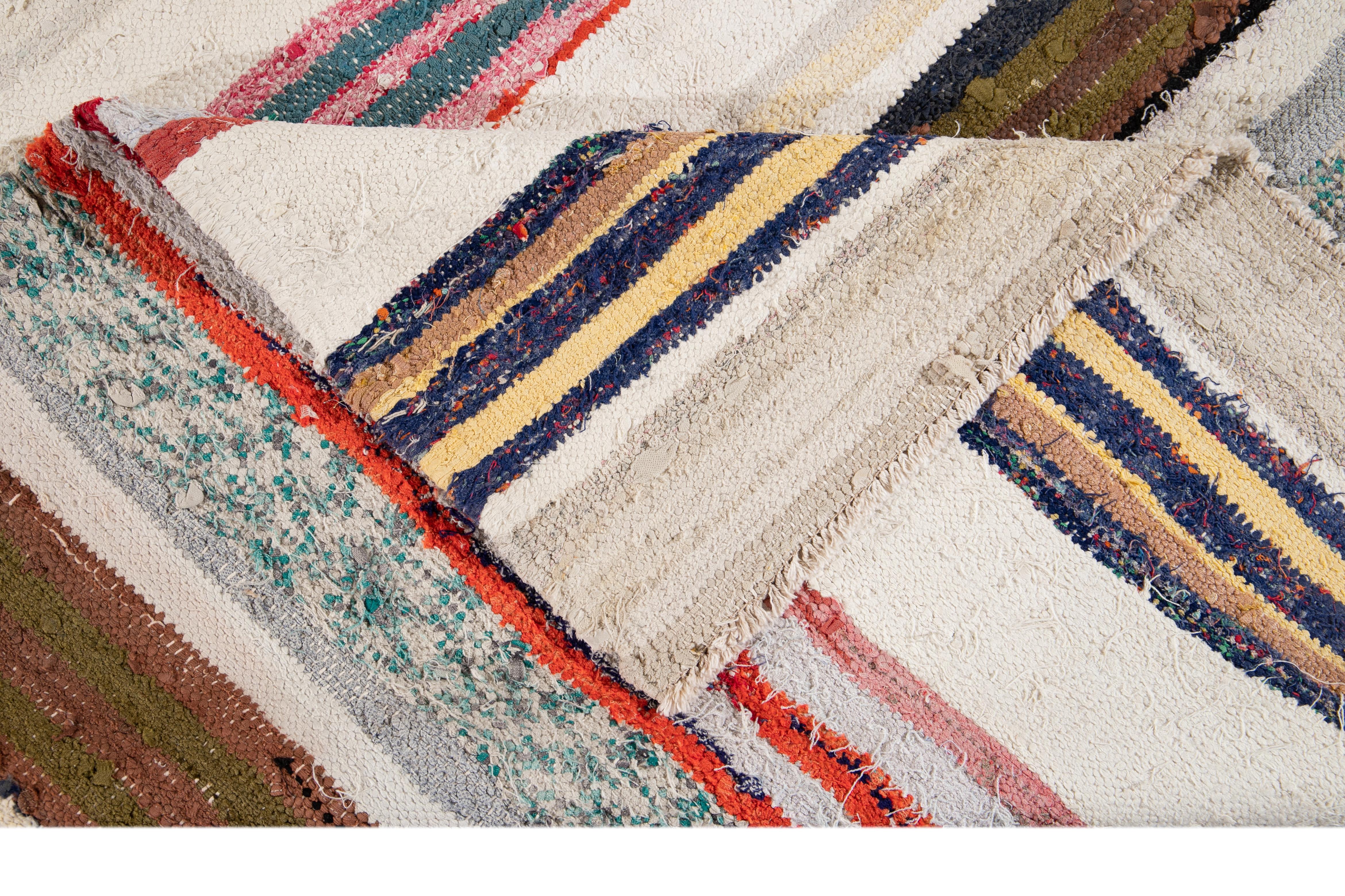 Beautiful hand knotted wool vintage Kilim rug. This rug has an ivory field with multicolored stripes, circa 1960

This rug measures 5' 2