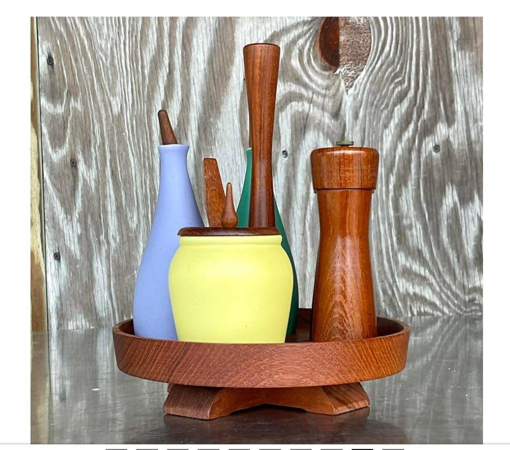 A fantastic vintage MCM Condiment Tray. Made by the iconic Italian group Arni Form and tagged on the bottom. Oil and vinegar, salt and pepper and sugar bowl all on top of a rotating lazy susan. Brightly colored ceramic vessels on a teak wood frame.
