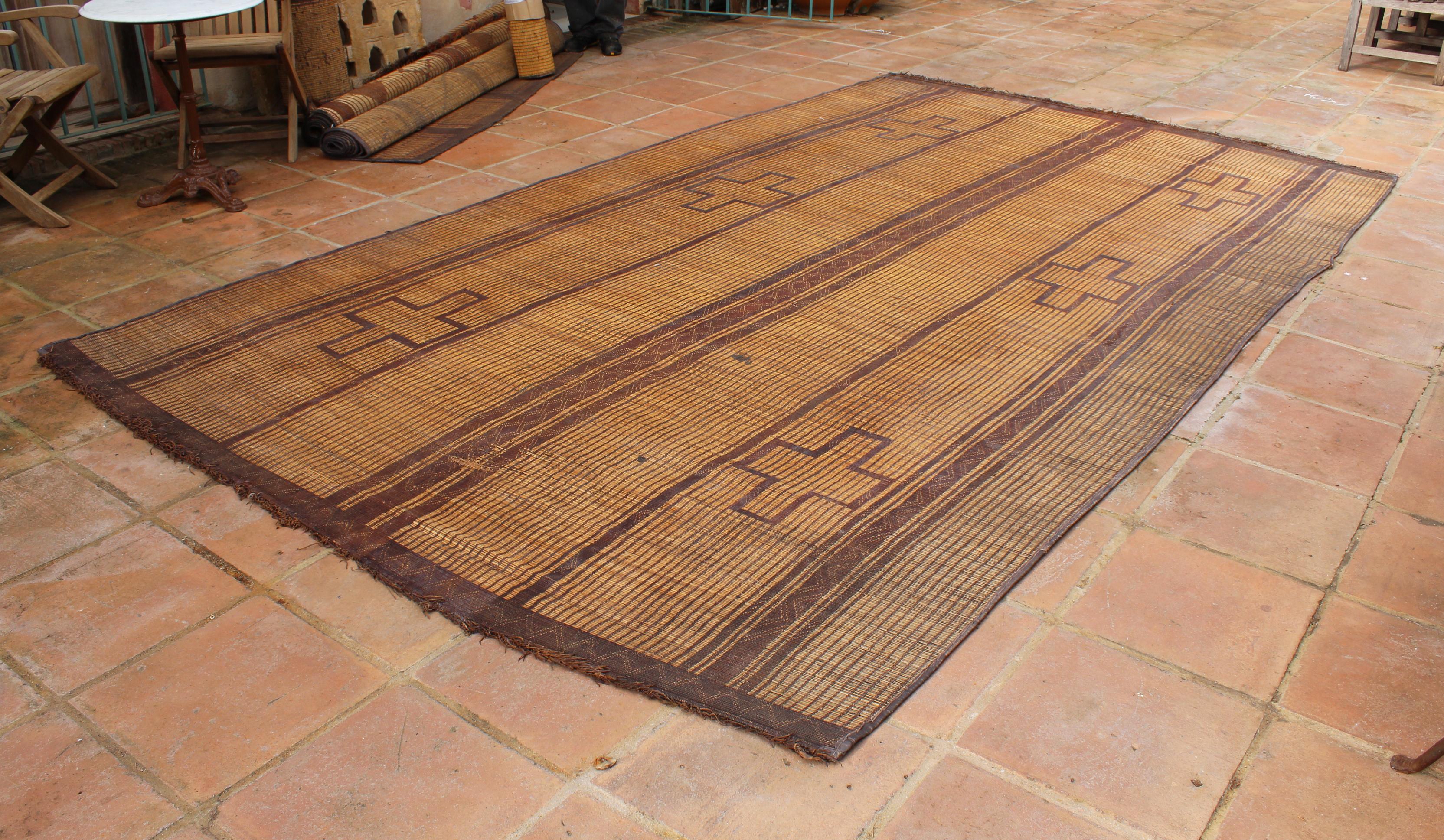 Mauritanian Tuareg leather mats are made of dwarf palm tree fibers and hand woven with leather stripes, this are great to use indoor or outdoor, beautiful brown earth-tone colors. This vintage midcentury carpets are made in Mauritania and have the