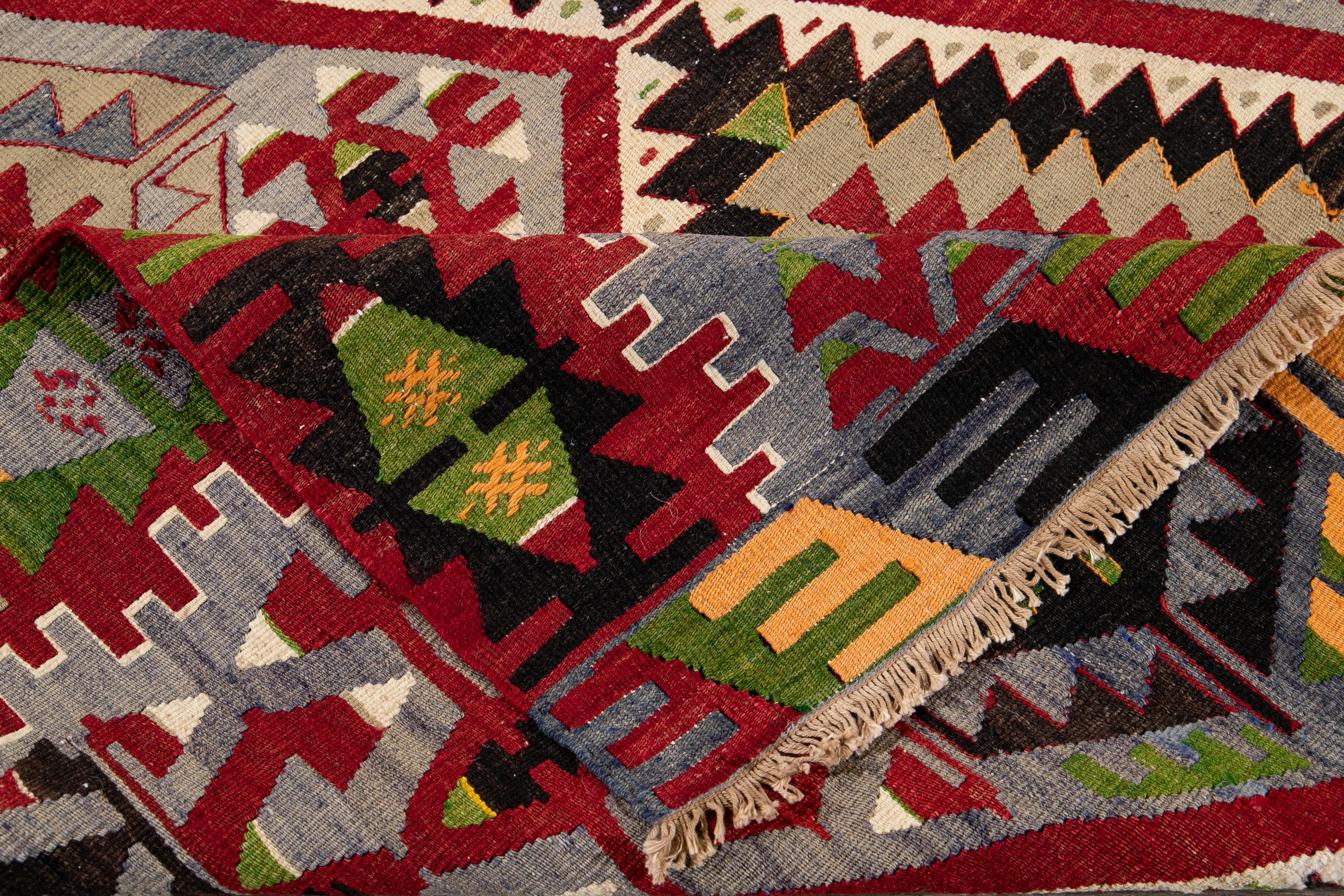 Beautiful vintage hand knotted Kilim wool rug with a gray field and multicolored geometric design all-over the rug. 

This rug measures 5' 5