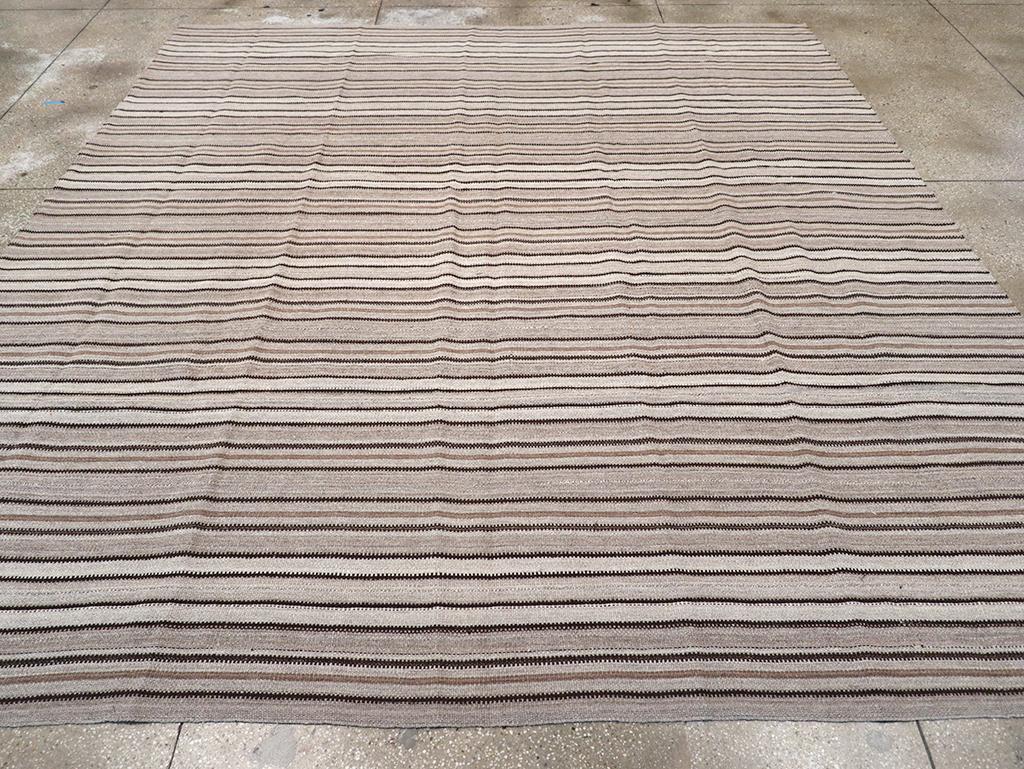 This Mid-20th century Persian Flatweave Kilim rug, measuring 10' 6
