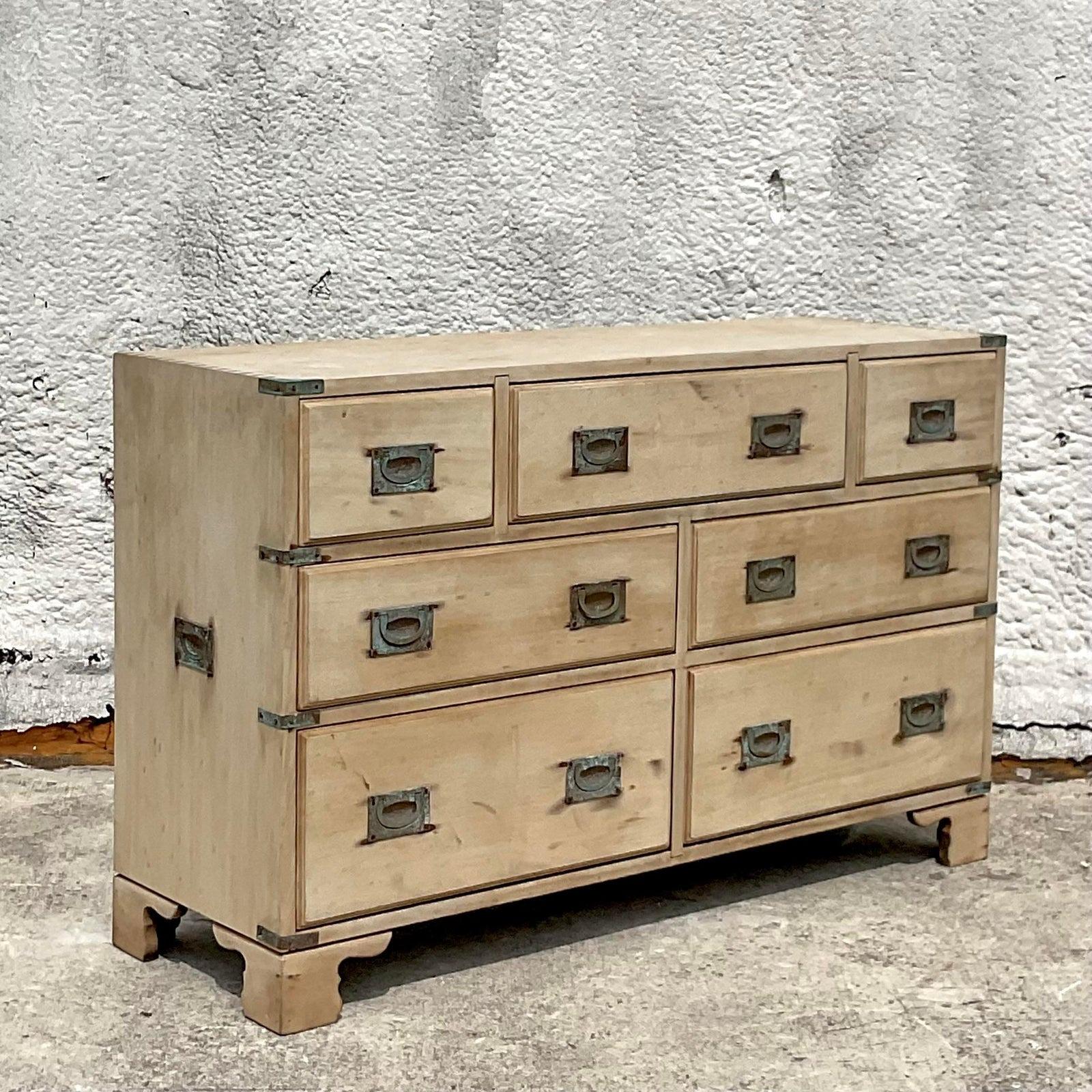 Enhance your décor with the timeless elegance of this Vintage Regency Bleached Wood Campaign Dresser. Marrying American style with Regency sophistication, this piece features sleek lines and practical storage in a beautifully bleached wood finish.