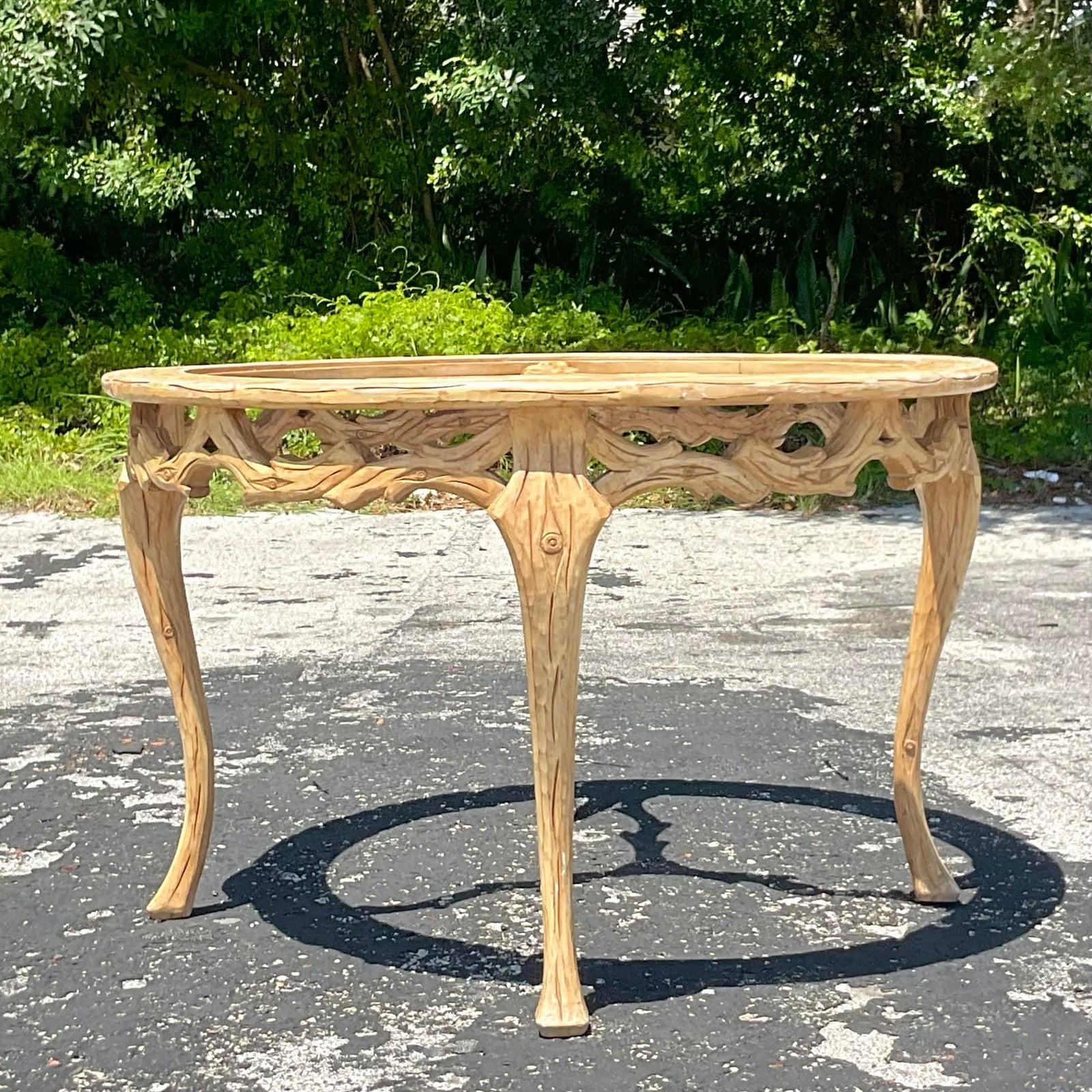 A stunning vintage Regency dining table. Beautiful hand carved detail in a classic Faux Bois design. Inset glass top. Acquired from a Palm Beach estate.

The table is in great structural shape. No scratches to the glass. The table would benefit from