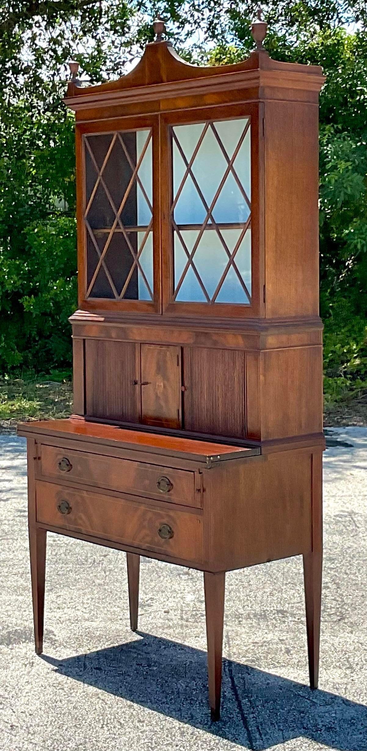 A fabulous vintage Regency Secretary desk. Beautiful flame mahogany cabinet with trellis million glass doors. Lots of great hidden storage and a flip out desktop. Acquired from a Palm Beach estate.

Desk open depth 26.5