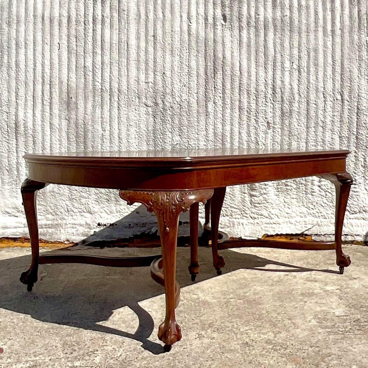 A stunning vintage Regency dining table. A chic Queen Anne shape with gorgeous hand carved Cabriolet legs. 4 additional leaves brings the total table length to a possible 118. Great for entertaining. Acquired from a Palm Beach estate.