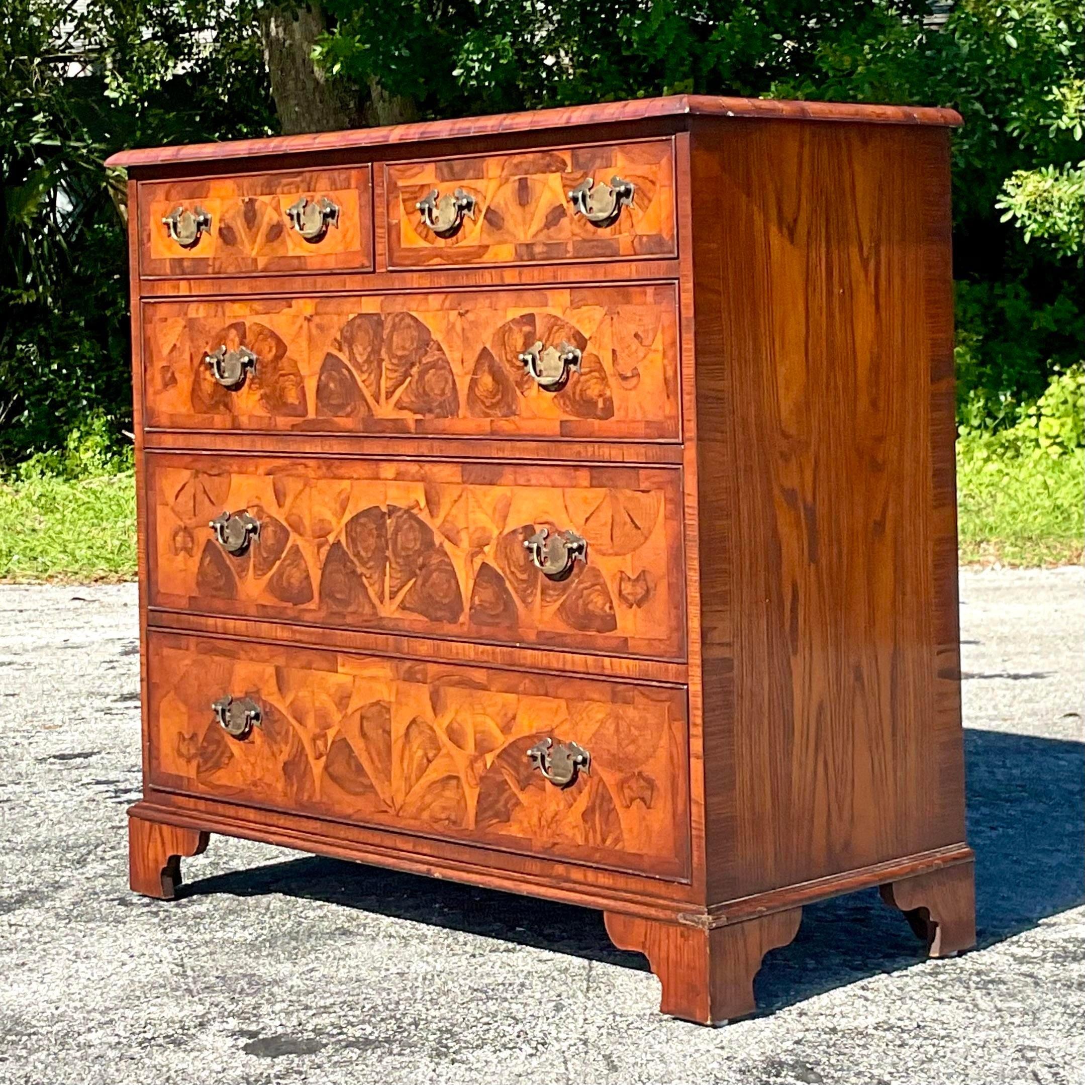 A superb vintage Regency chest of drawers. A gorgeous combination of marquetry and inlay details. Stunning oyster Burl wood detail with brass hardware. Acquired from a Palm Beach estate.