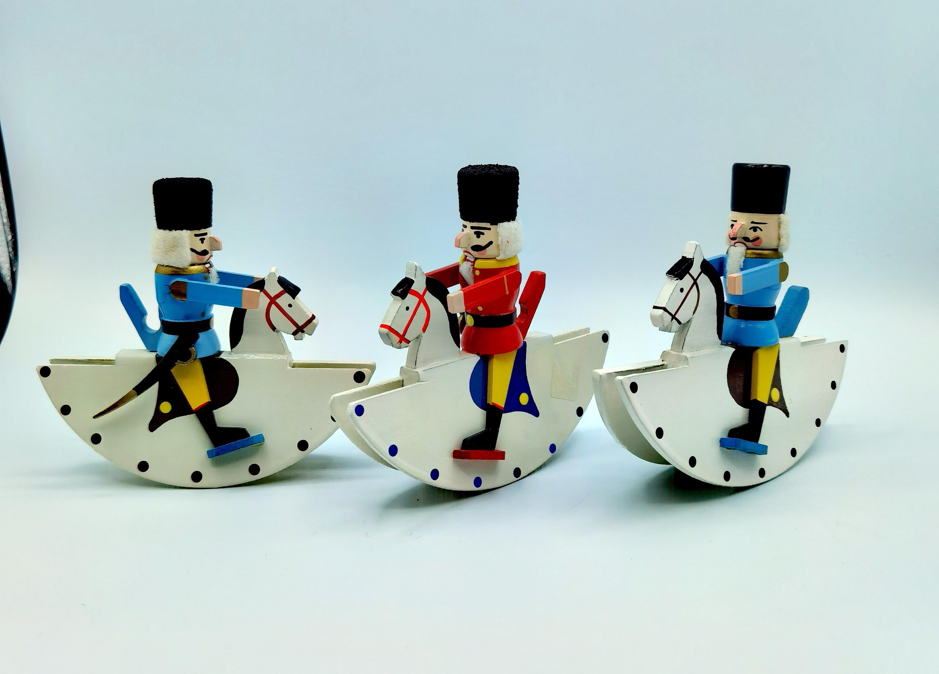 Set of three vintage German christmas nutkracker sculptures handmade in wood. Mid-20th century from the Erzgebirge. The traditional hand carved nutcrackers are hand painted in wood and sitting on a rocking horse. Stamped made in Germany.
A