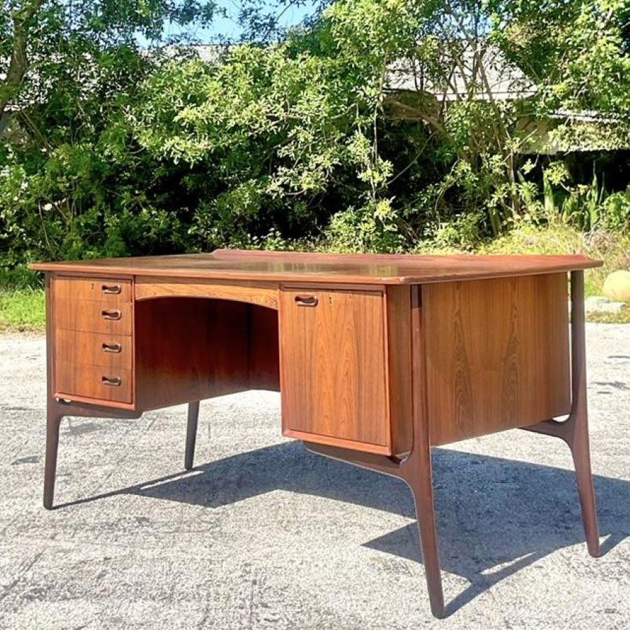 Experience timeless elegance with our Vintage MCM Sven Madsen Danish Teak Writing Desk, a true testament to American mid-century modern craftsmanship. Meticulously crafted from teak wood, this desk combines sleek Danish design with practical