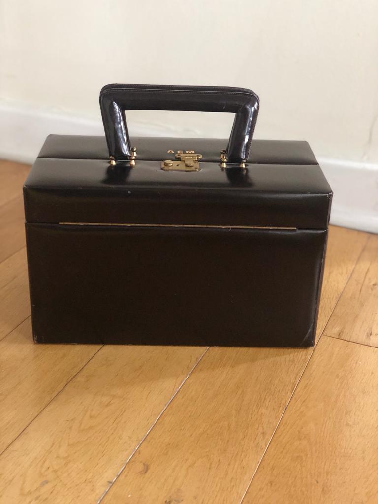 Vintage midcentury leather (Dark Brown) travel case by Asprey of London. Some scuffs, rubbing, surface marks, signs of use consisting with age. Lock but no key. Monogrammed: A E M Original satin lining, which has a clear plastic cover fixed to