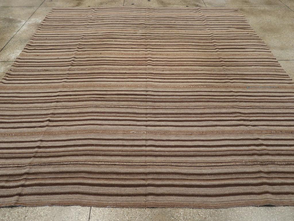 This Mid-20th century Turkish Flatweave Kilim rug, measuring 10' 3