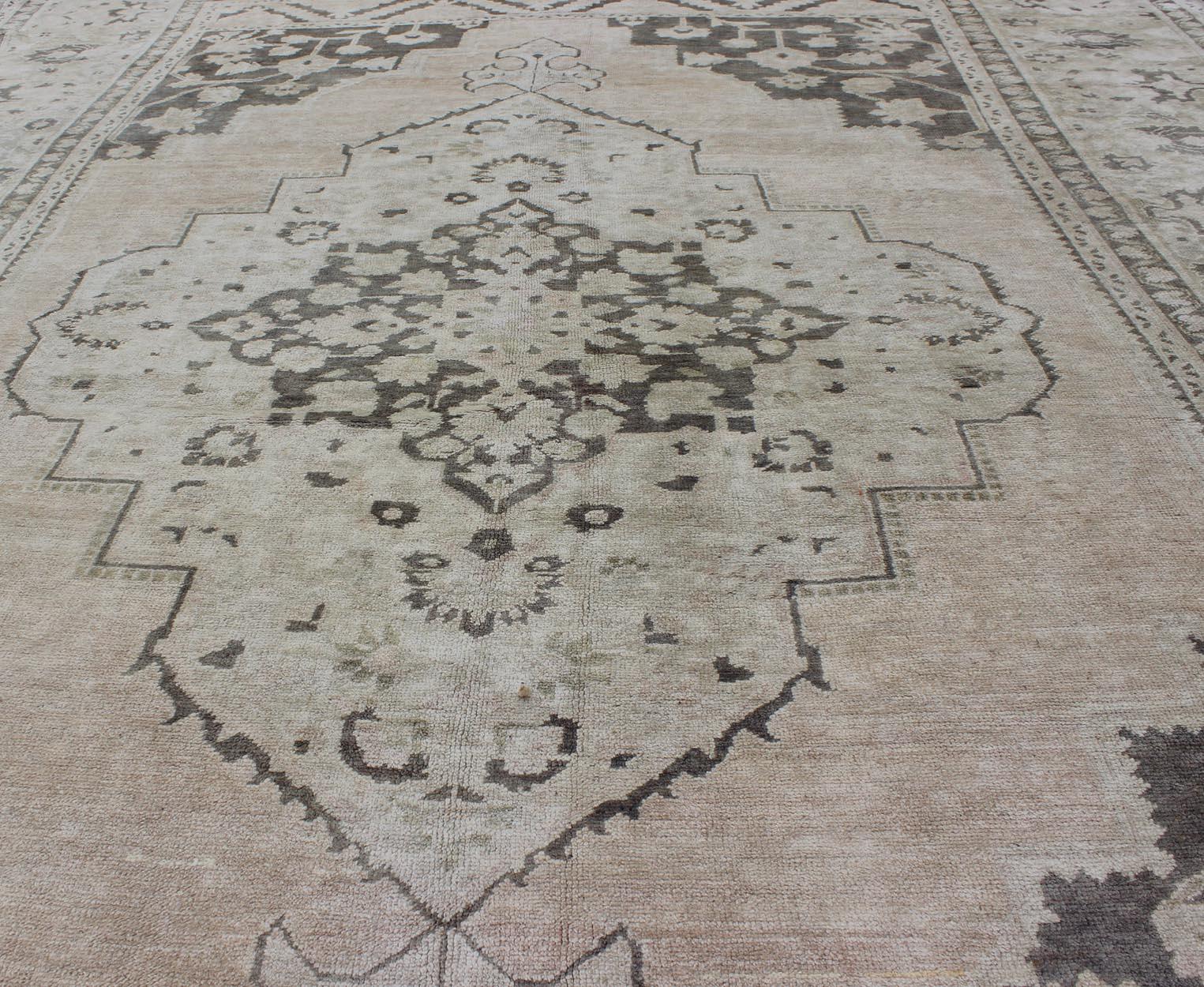 Annodato a mano Tappeto Oushak turco d'epoca della metà del XX secolo con disegno a medaglione in toni tenui in vendita