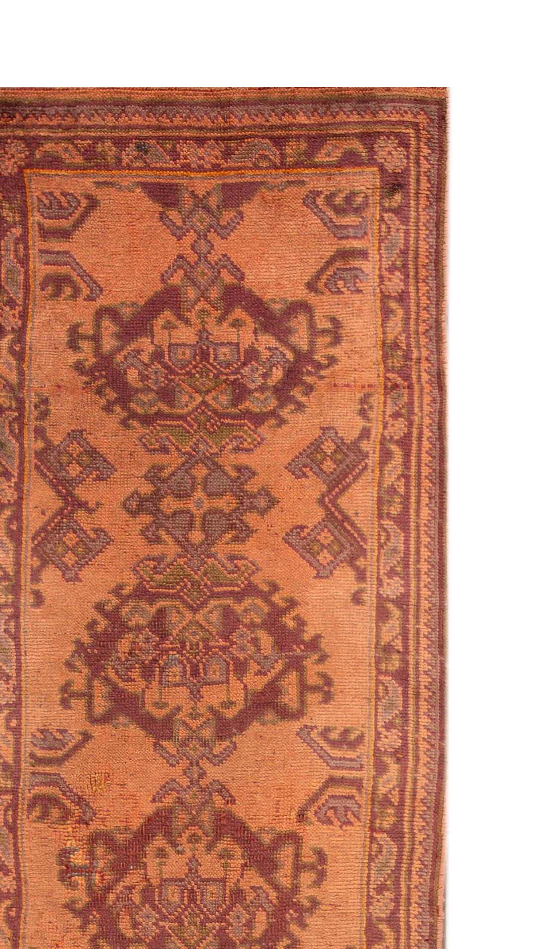 Beautiful hand-knotted Oushak style wool rug with an orange field with brown mandala accents. 

This rug measures 3' x 11' 8