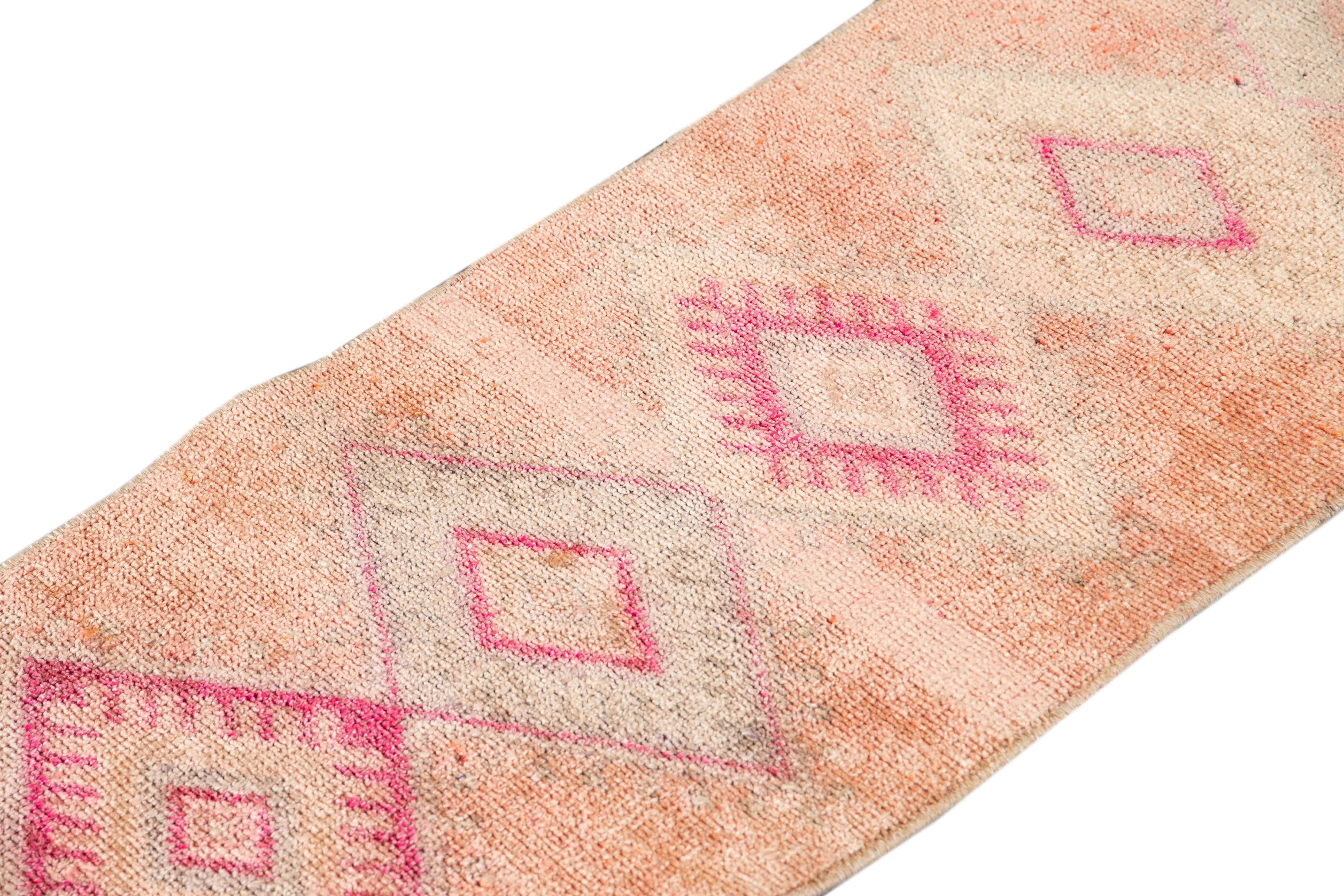 Beautiful vintage runner rug, hand knotted wool with a light peach field, pink and gray accents in multi medallion design,
circa 1940.
This rug measures 1' 9