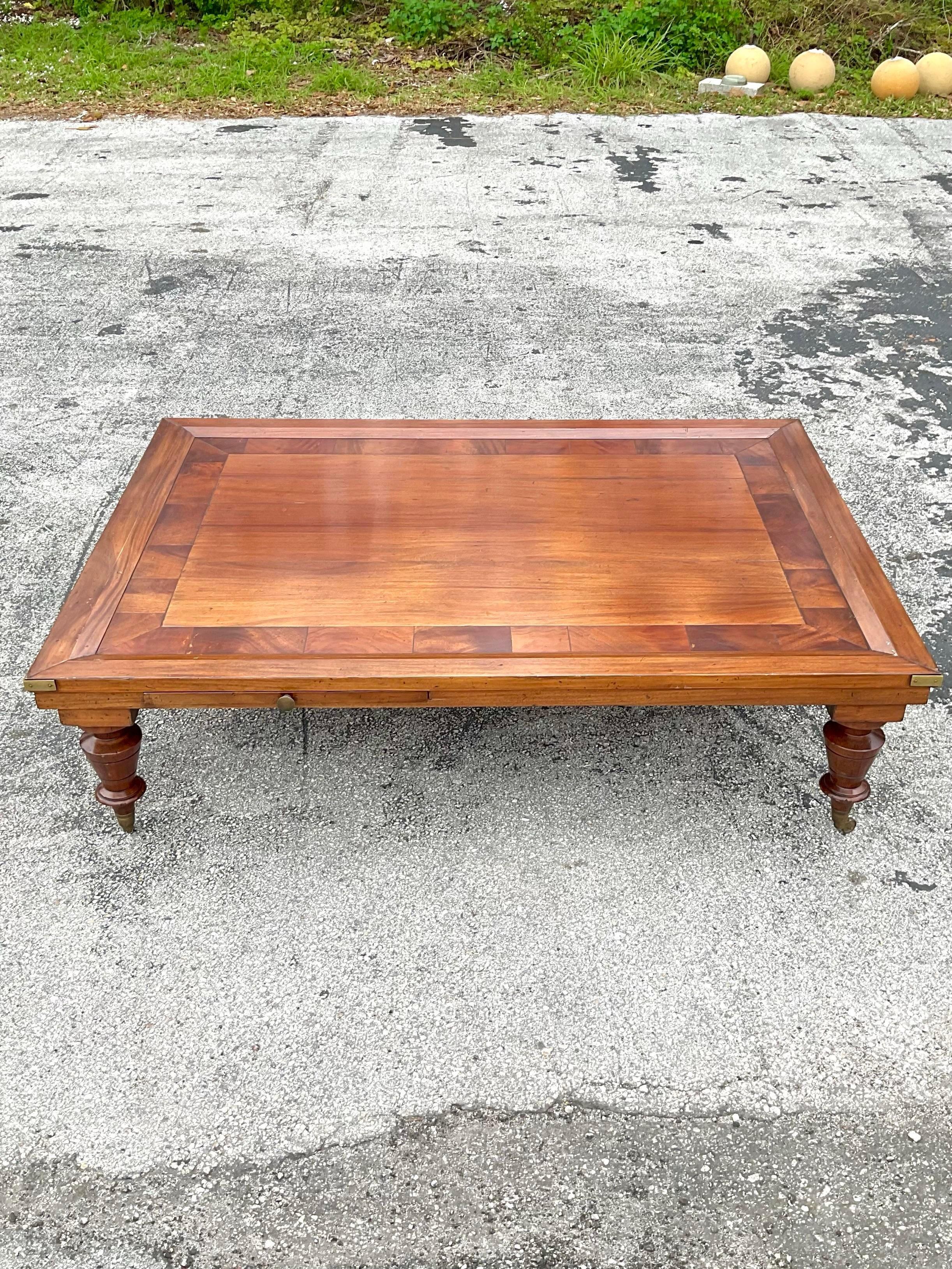 Fantastic vintage coffee table with intricate inlay work bordering the exterior. The details on this table are exquisite, brass accents throughout. Handles on both ends and brass casters ending perfectly carved tapered legs. There are two extendable