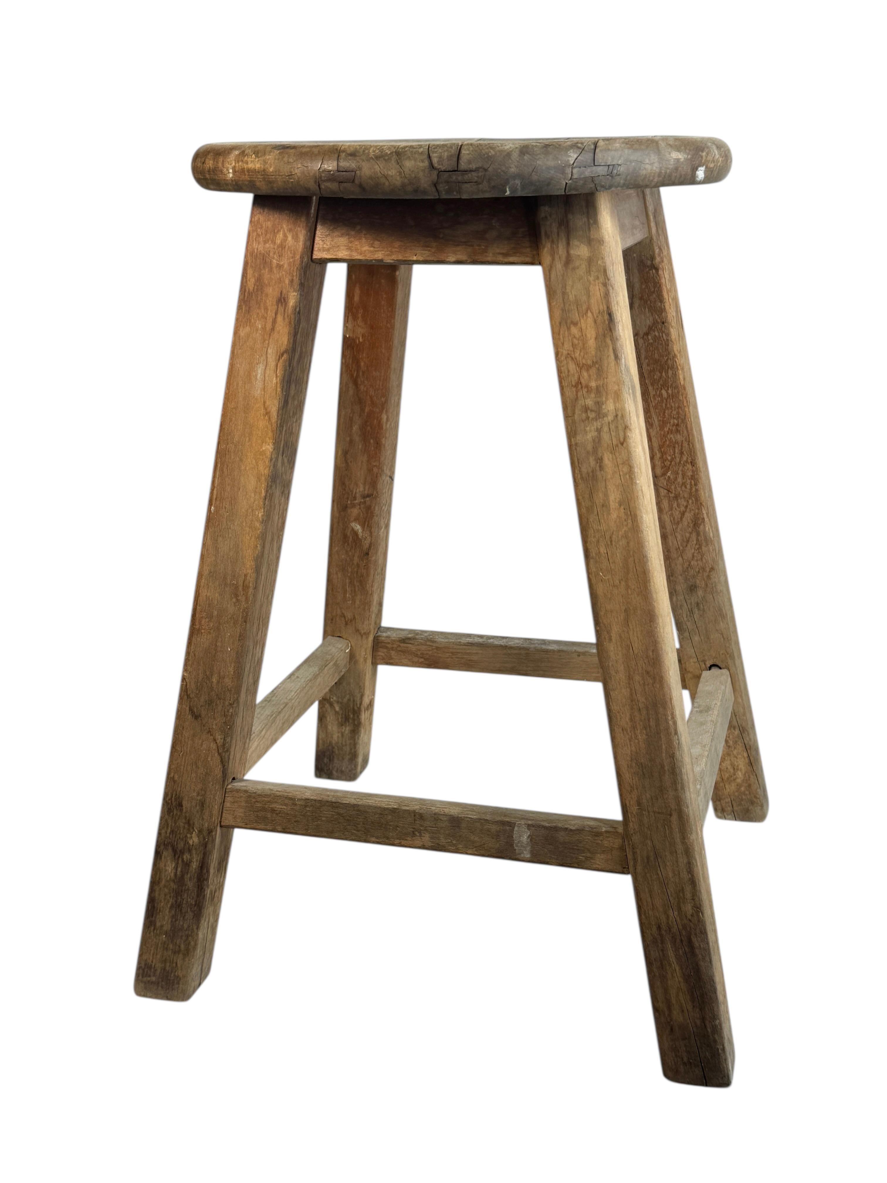 Questo sgabello wabi sabi a 4 gambe della metà del XX secolo, proveniente dall'Austria, è un eccellente esempio di questo stile. Il pezzo ha una seduta quadrata dall'aspetto rustico realizzata in legno e sostenuta da tre gambe in legno. Lo sgabello