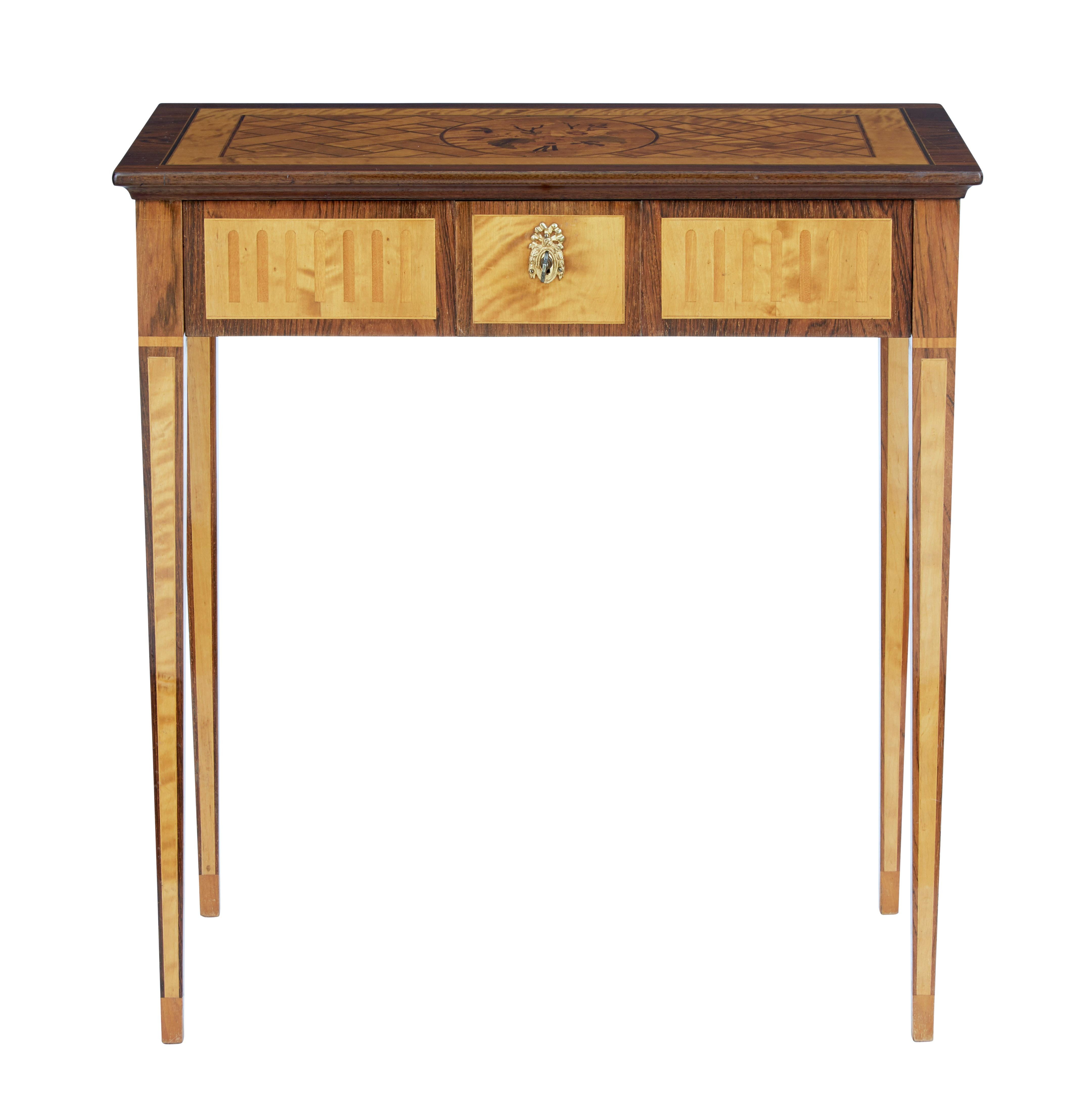 Beautifully inlaid occasional table made in Sweden in the 1940s.

Top inlaid with a central floral motif further strung with walnut and satinwood forming a pattern. Single drawer with fitted partitions working key and lock.

Standing on 4