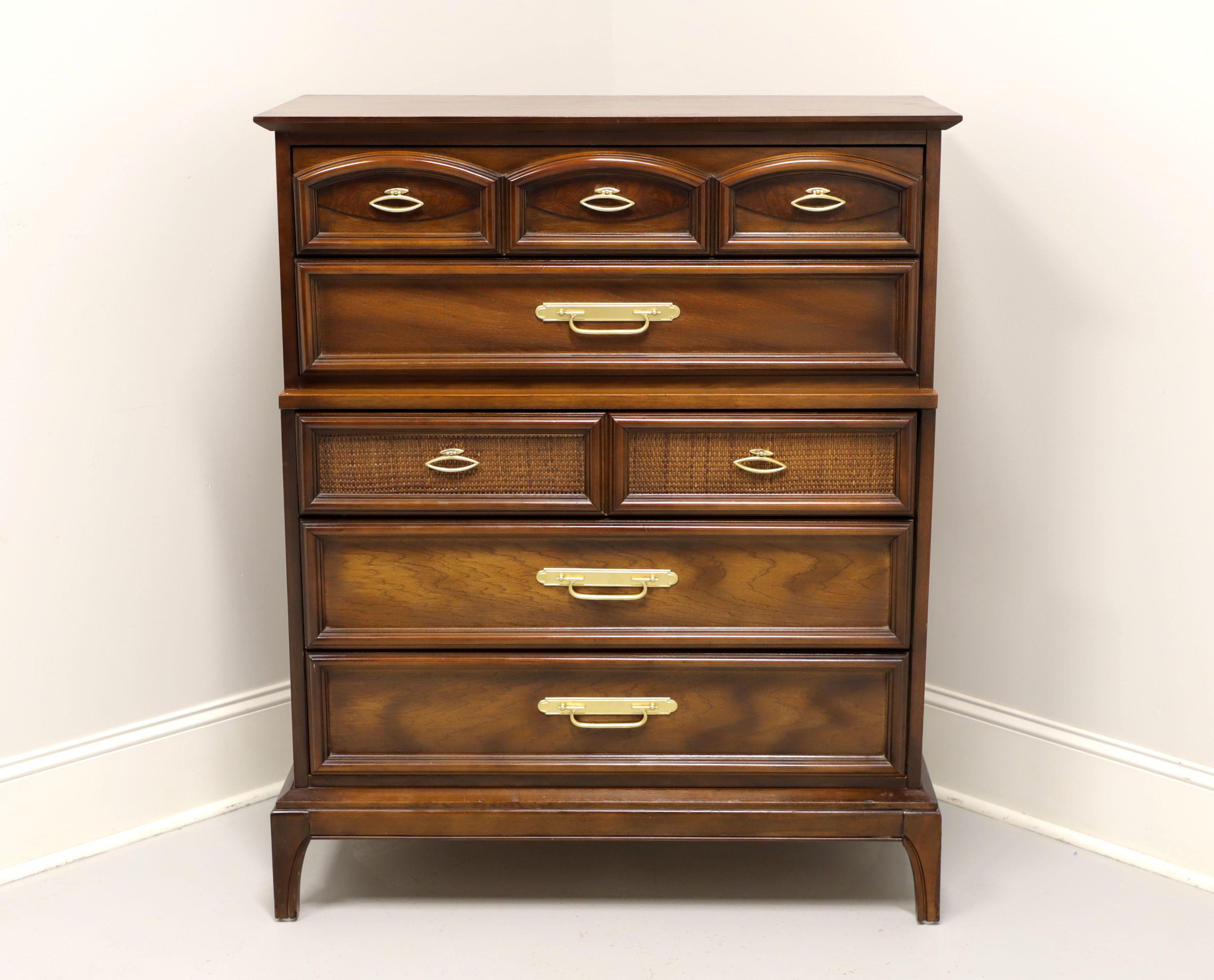 An Asian influenced Mid-Century chest of drawers, unbranded, similar quality to Thomasville. Walnut with brass hardware, burl accent to top drawer, rattan acccent to middle drawer, and splayed feet. Features five drawers of dovetail construction.