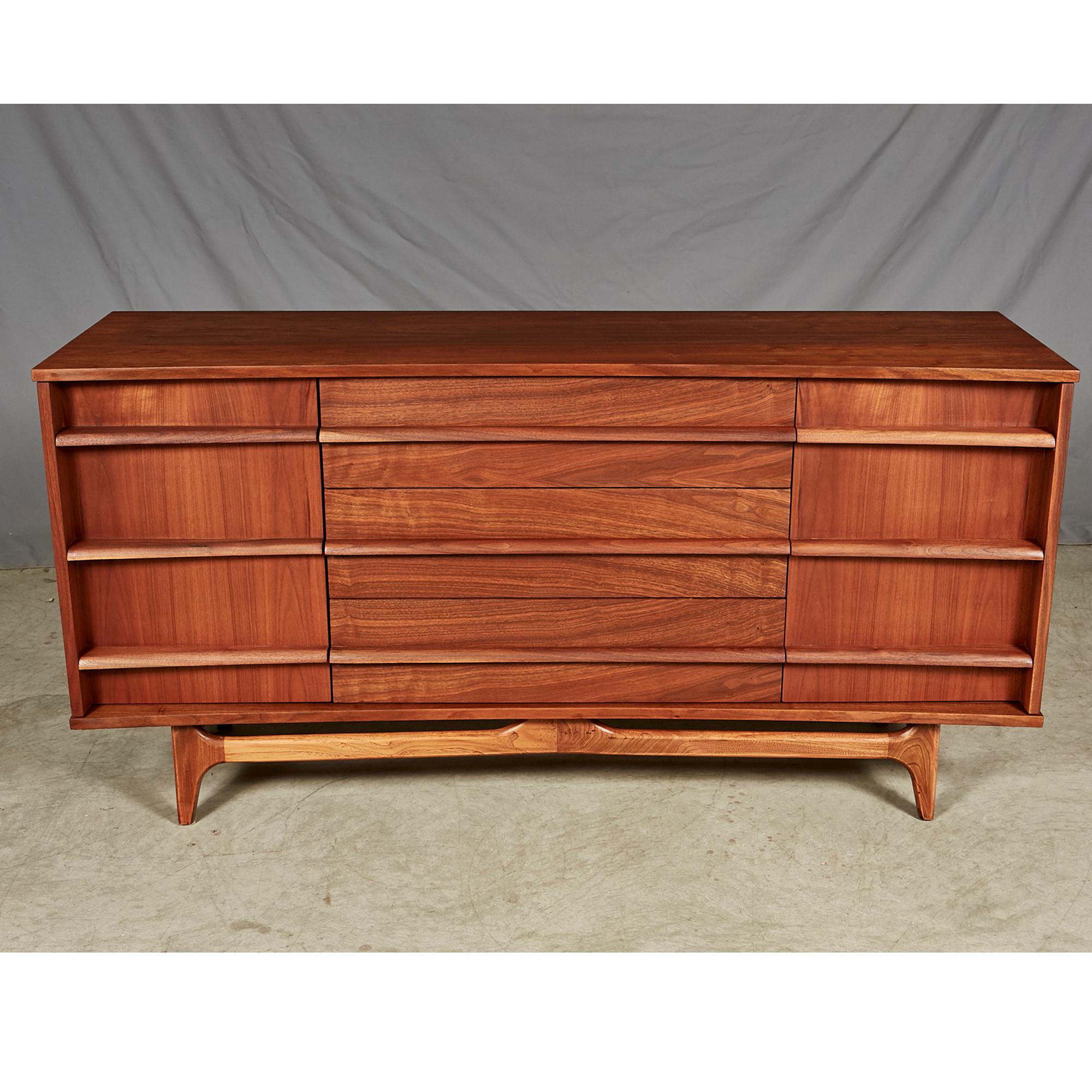 Vintage 1950s walnut wood curved front sideboard with three drawers and shelving for storage. In excellent refinished condition. No maker's mark.
 