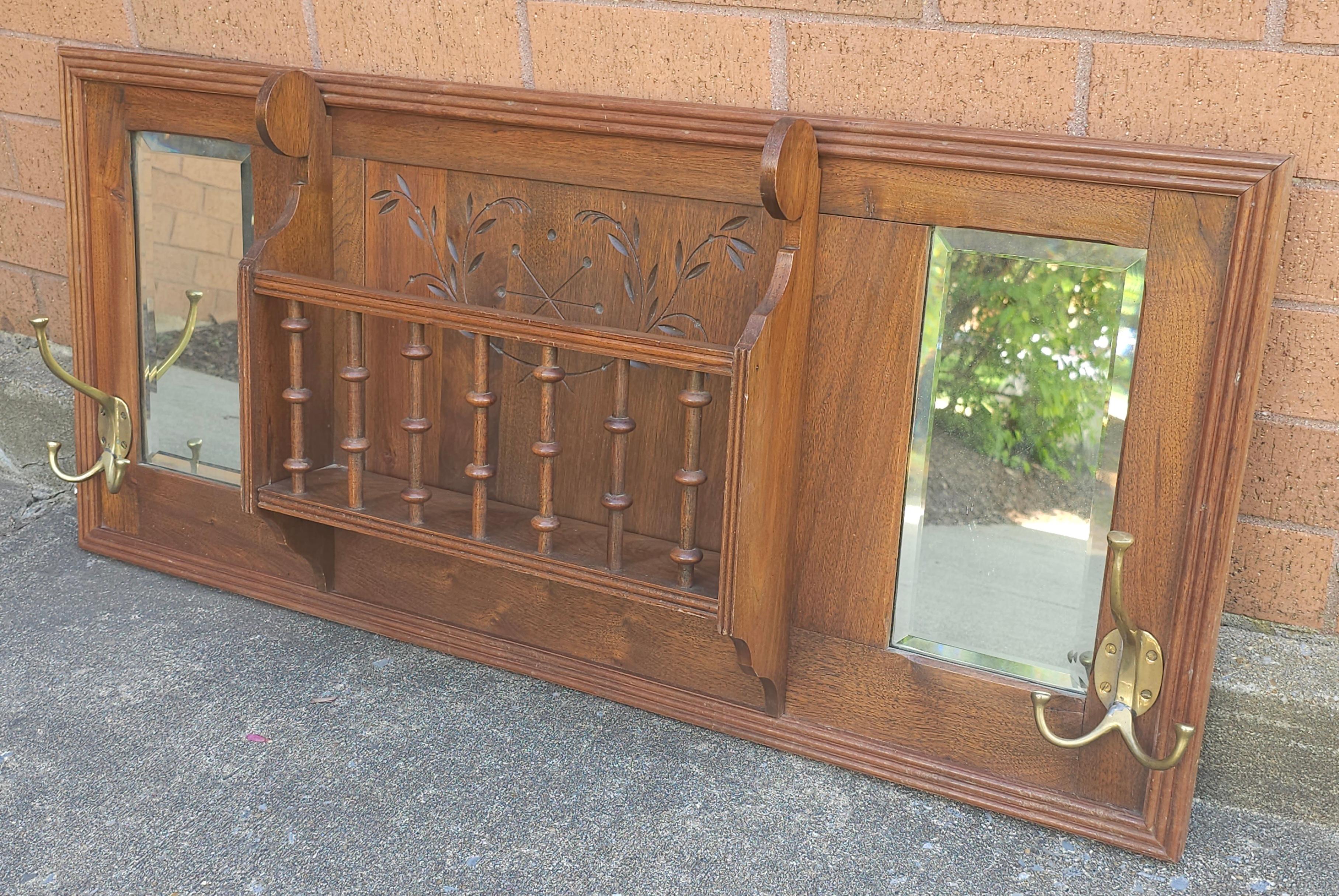 A Mid-20th Century Walnut Double bevel Mirrored Coat and Hat Rack with a Spindle Storage Slot. Measures 39