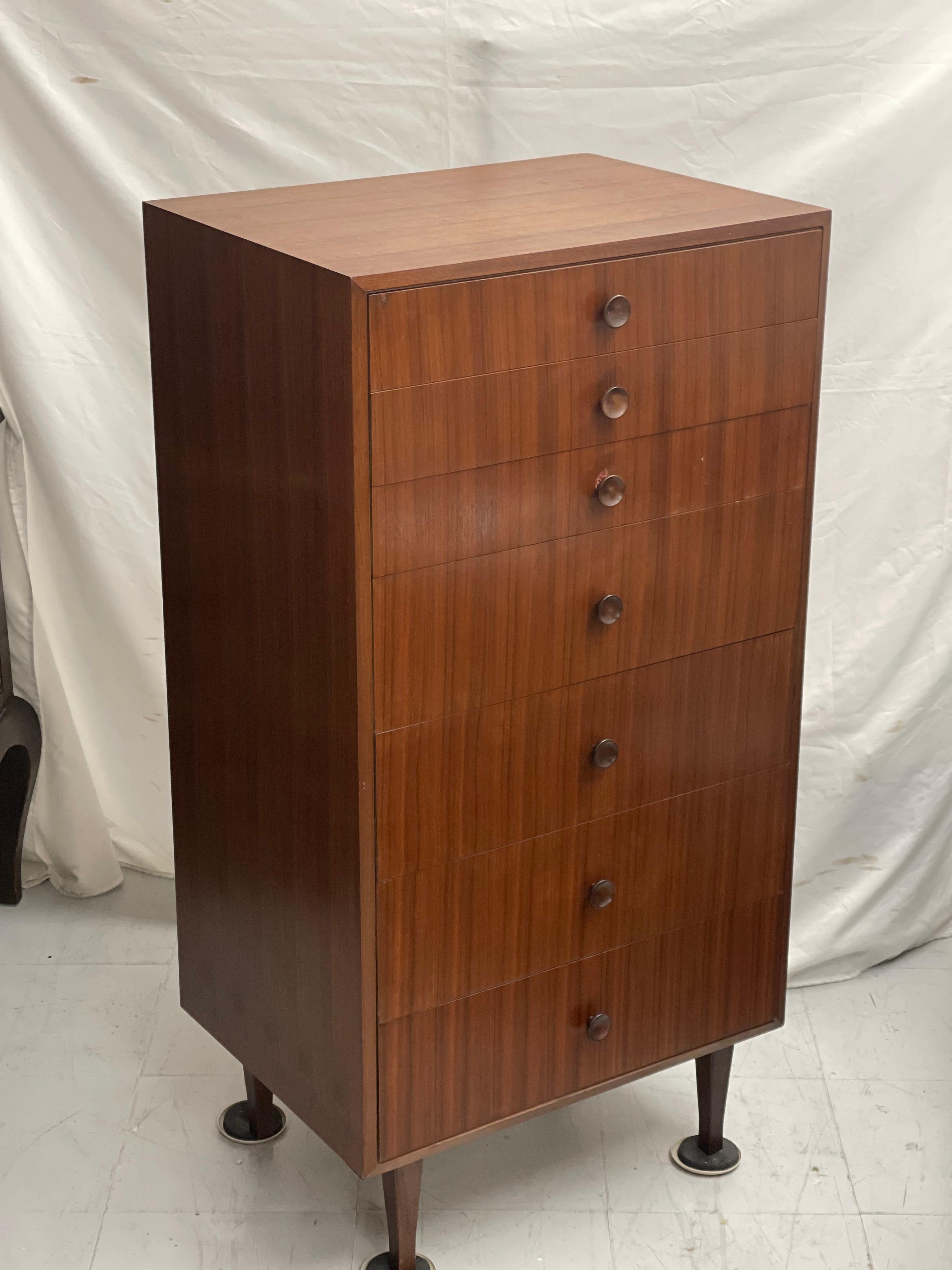 This is a vintage English dark walnut tall chest of drawers, tallboy or dressing chest with 7 drawers dating from the mid twentieth century. Approximate dimensions are 24 W 18 D 47 H.