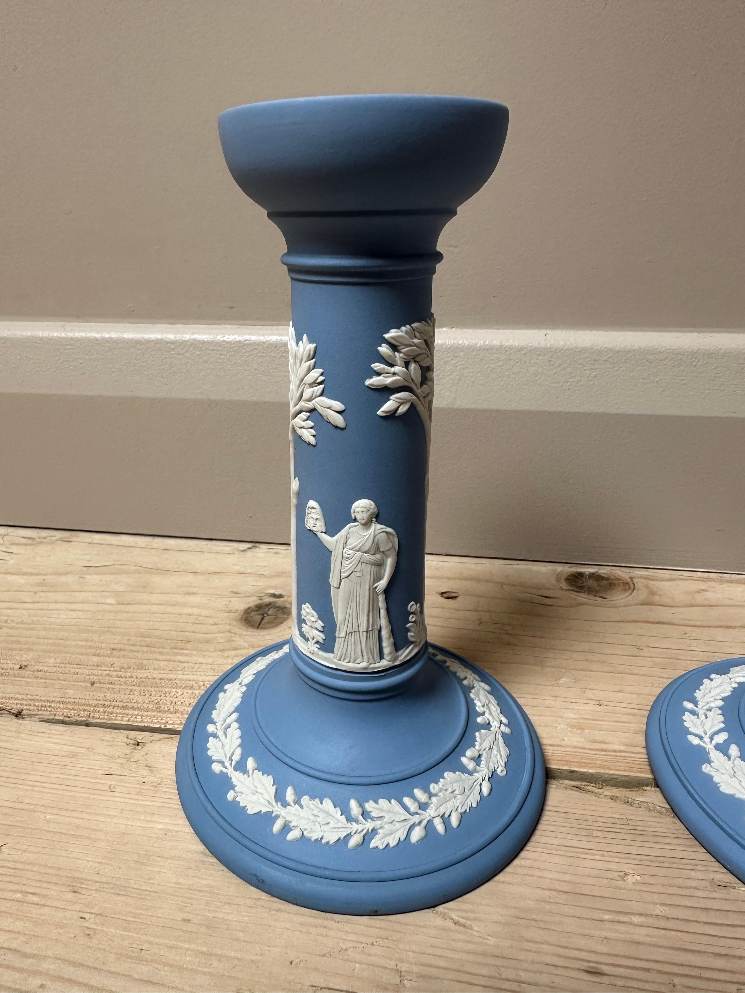 Dieses elegante Paar Vintage-Kerzenhalter von Wedgwood ist aus der für die Marke typischen blau-weißen Jasperware gefertigt, einer zeitlosen Keramik, die für ihre matte Oberfläche und ihr klassisches Design bekannt ist. Diese Kerzenhalter sind in