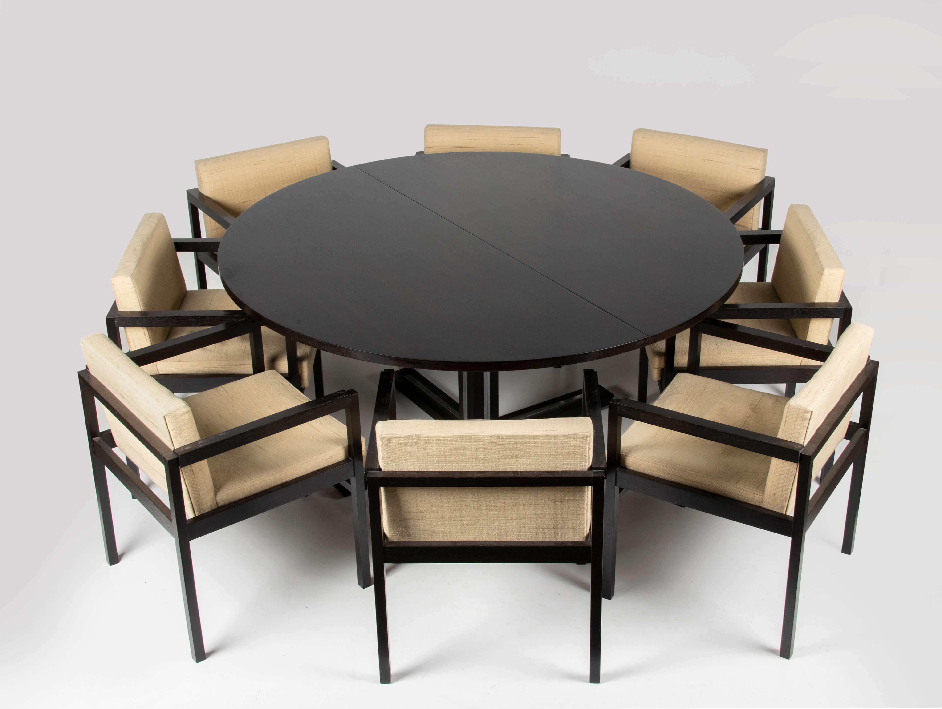 Beautiful large round wenge dining table with 8 matching chairs in the style of Jules WABBES. The table can be extended with two original leaves. If there are 6 chairs at the table, everyone is more spacious. The 8 chairs are especially useful when