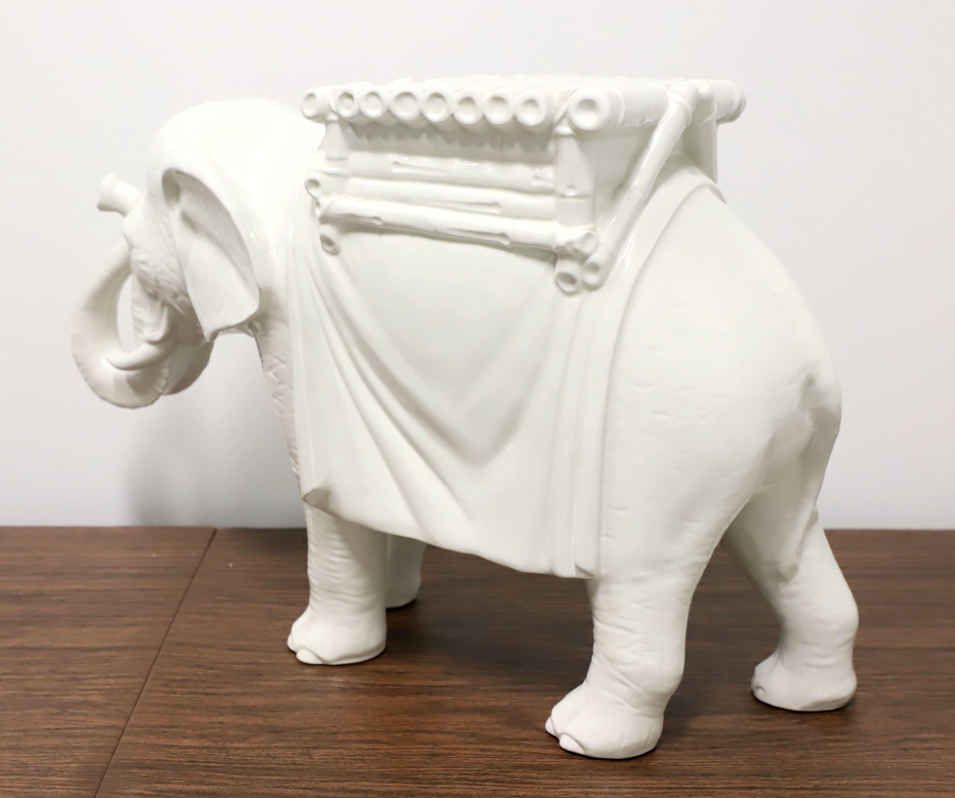 An Asian style ceramic elephant plant stand / garden stool, unbranded. White painted glazed porcelain in the shape of a traditionally garbed Asian elephant. Likely made in Asia, in the mid 20th Century.

Measures: 25w 8.5d 15.5h, Weighs