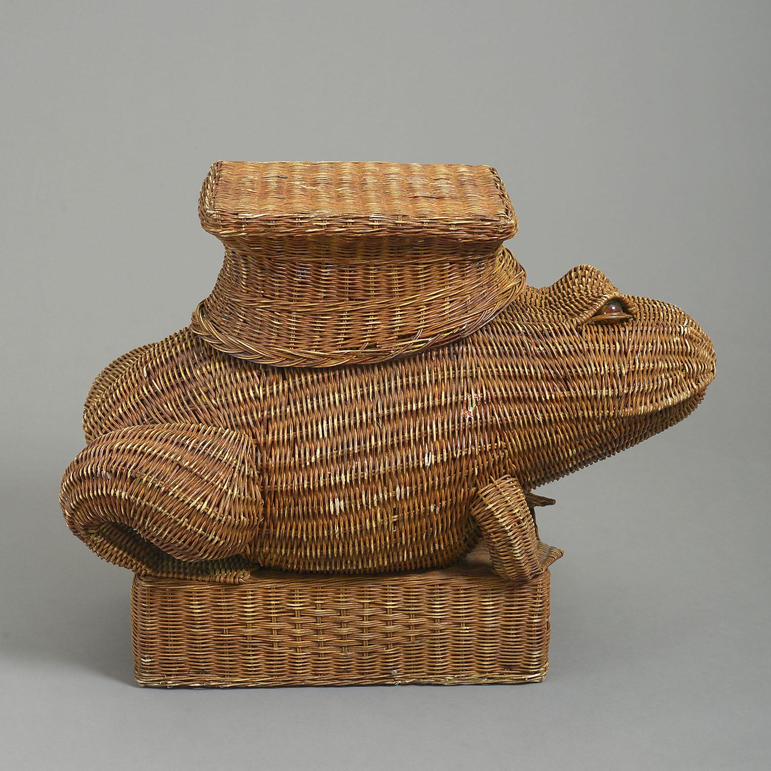 A charming mid-century wicker work frog table with glass eyes supporting a table surface on its back and standing on a platform base.