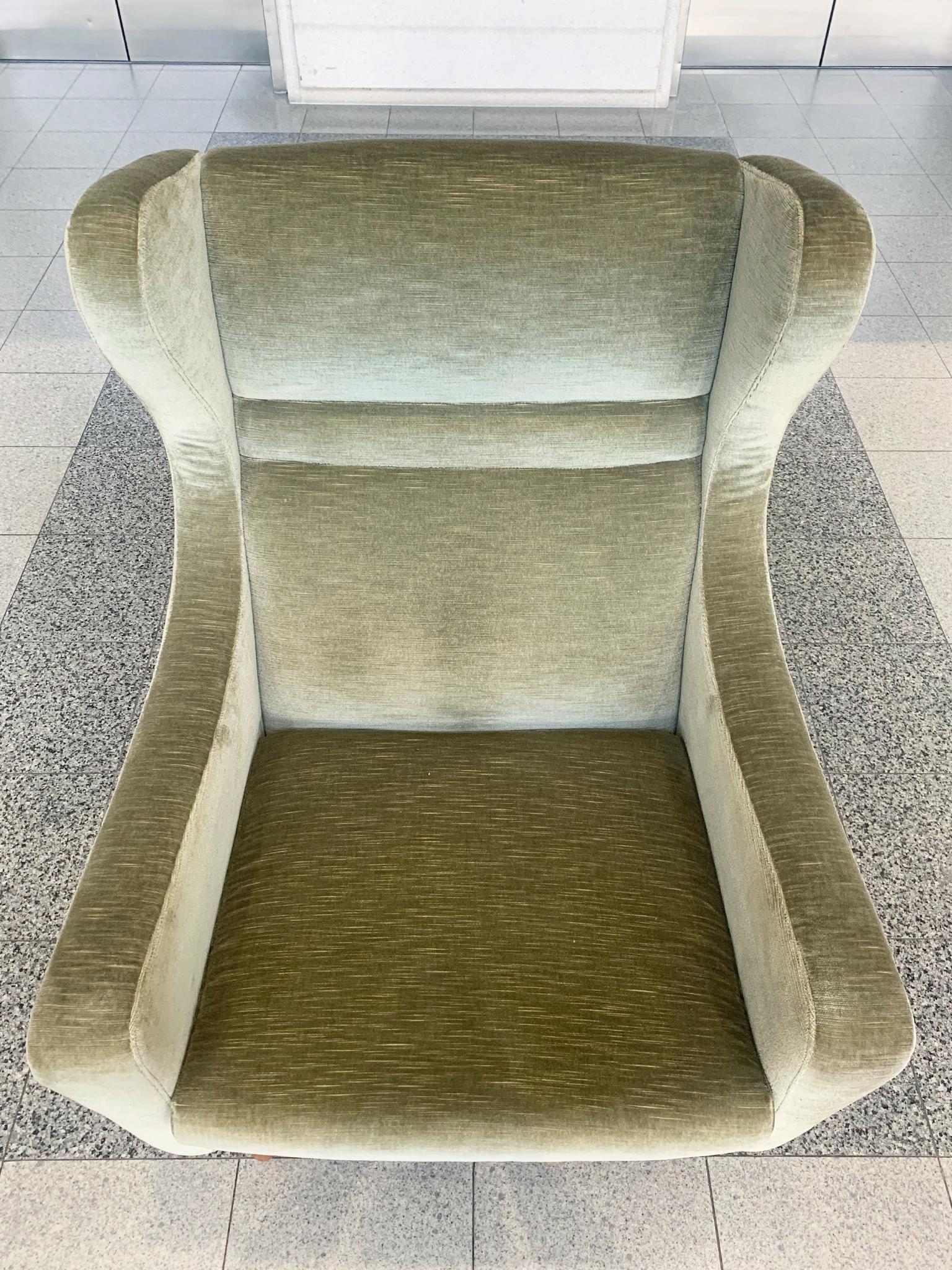 Classic Danish Modern wingback with a lovely moss-green upholstery and teak legs, made by Rolschau Møbler in the Mid-20th Century. We love the dramatic slope of the arms and the tufted detailing of the back. There's a warm, inviting character to