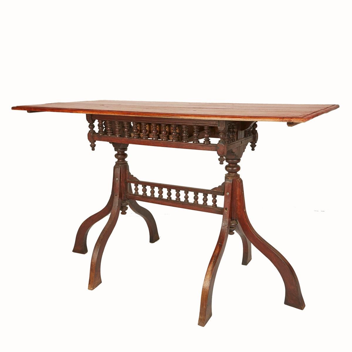 A singular one-drawer desk or writing table from Inle Lake, Myanmar (formerly Burma), circa 1930. Its hand-carved spindled apron and stretcher, along with the singular tripod legs, make this charming table a rare and original item that will make an