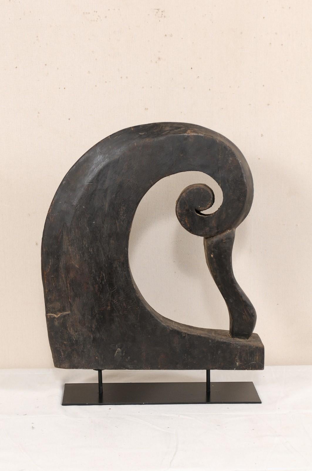 A South Indian (Kerala) wooden boat prow from the mid-20th century, with custom stand. This vintage hand carved boat prow from Kerala is adorn with pierced curling volute, reminiscent of a curling wave. It is supported upon a custom black iron